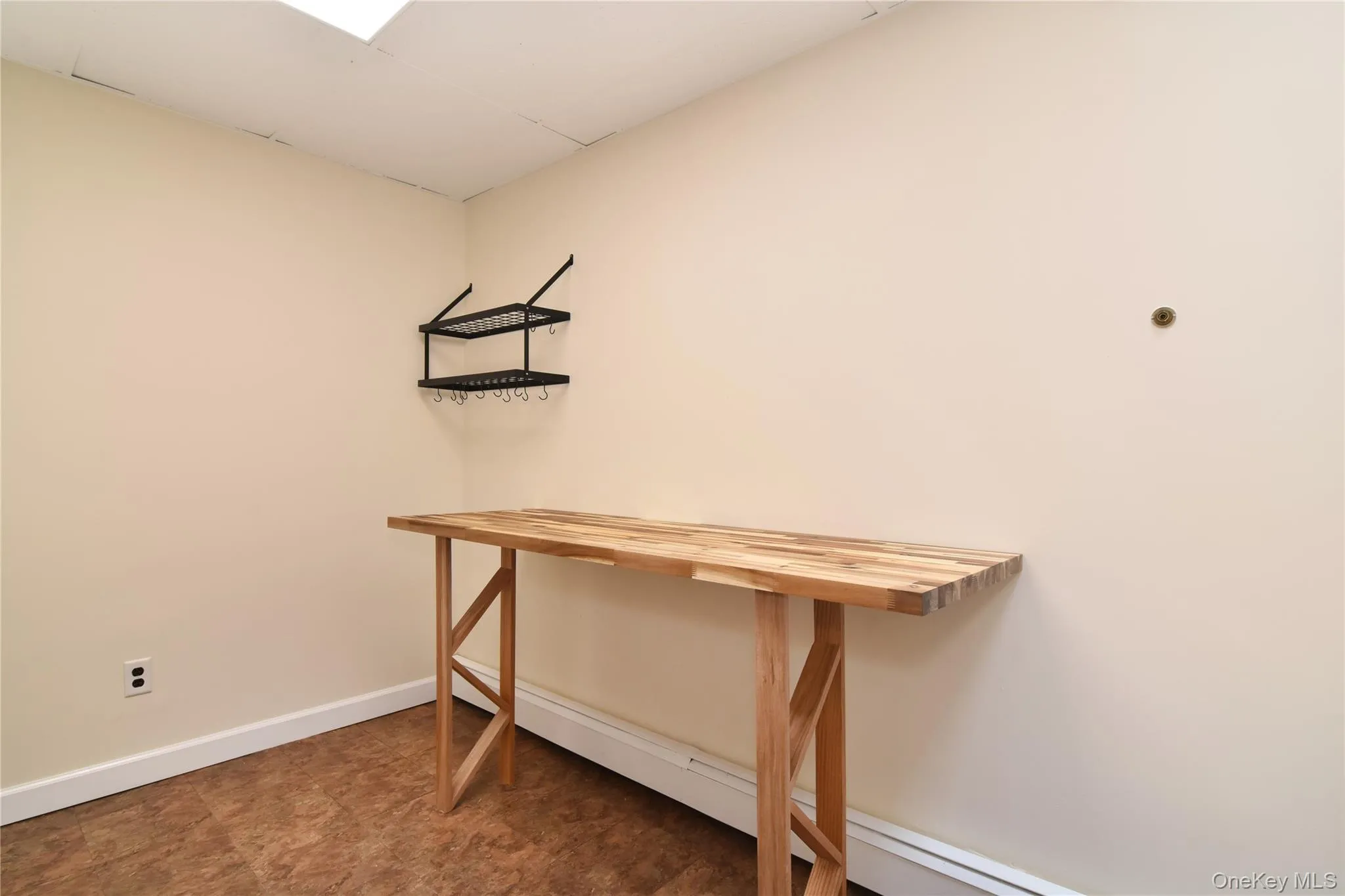 Another view of the kitchen featuring a butcher block table and storage rack. Another view of the kitchen featuring a butcher block table and storage rack.