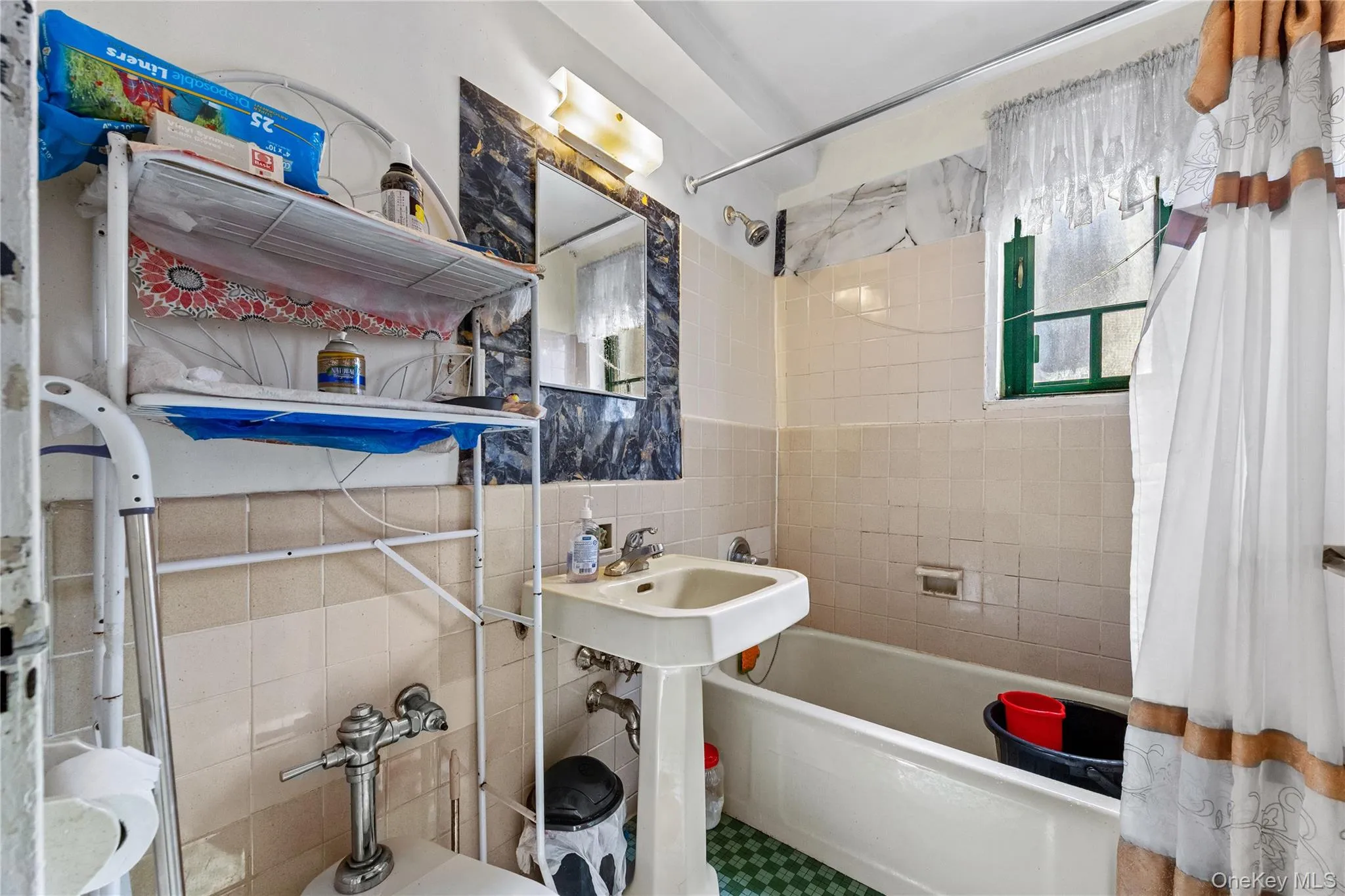 Bathroom featuring a pedestal sink, wall-mounted vanity lighting, recessed soap dish, and a combined bathtub and shower with tiled surround Bathroom featuring a pedestal sink, wall-mounted vanity lighting, recessed soap dish, and a combined bathtub and shower with tiled surround