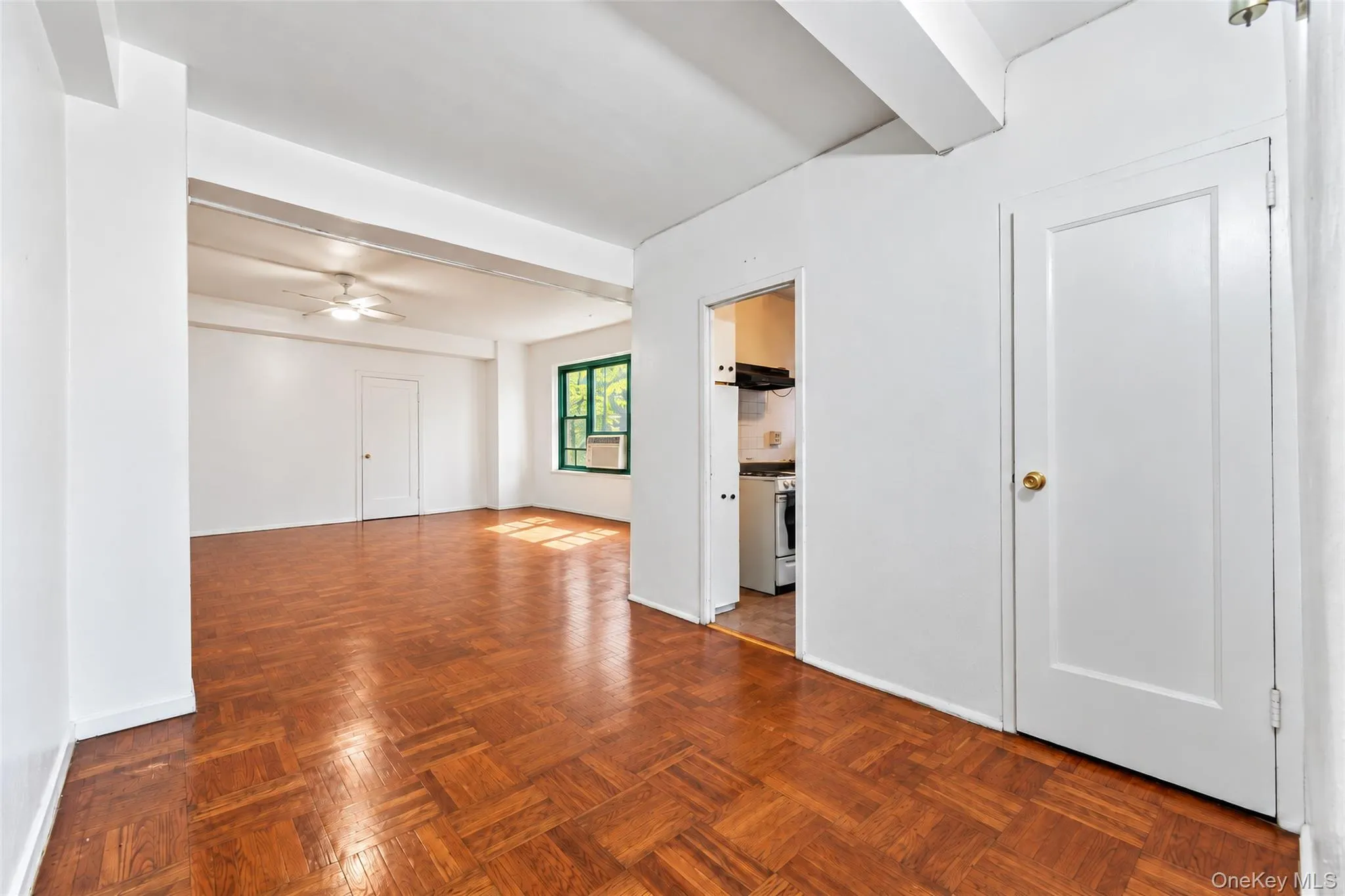 Parquet wood-finish flooring, exposed structural ceiling beams, solid-core interior doors, and multi-pane window Parquet wood-finish flooring, exposed structural ceiling beams, solid-core interior doors, and multi-pane window