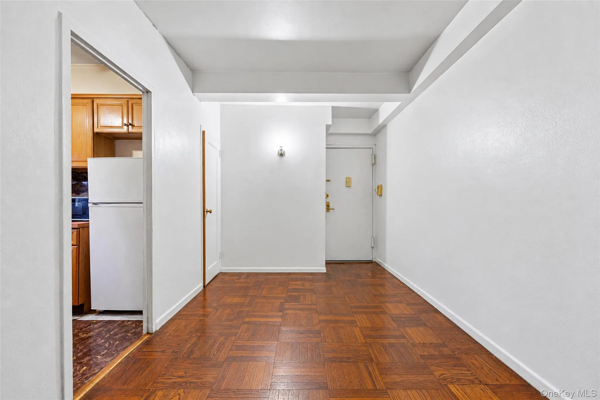 Parquet wood-finish flooring, white walls, and a recessed ceiling beam Parquet wood-finish flooring, white walls, and a recessed ceiling beam