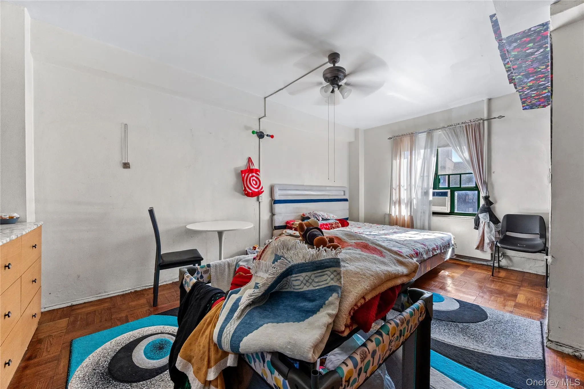 Parquet wood-finish flooring, ceiling-mounted fan with integrated lighting, and multi-pane window Parquet wood-finish flooring, ceiling-mounted fan with integrated lighting, and multi-pane window