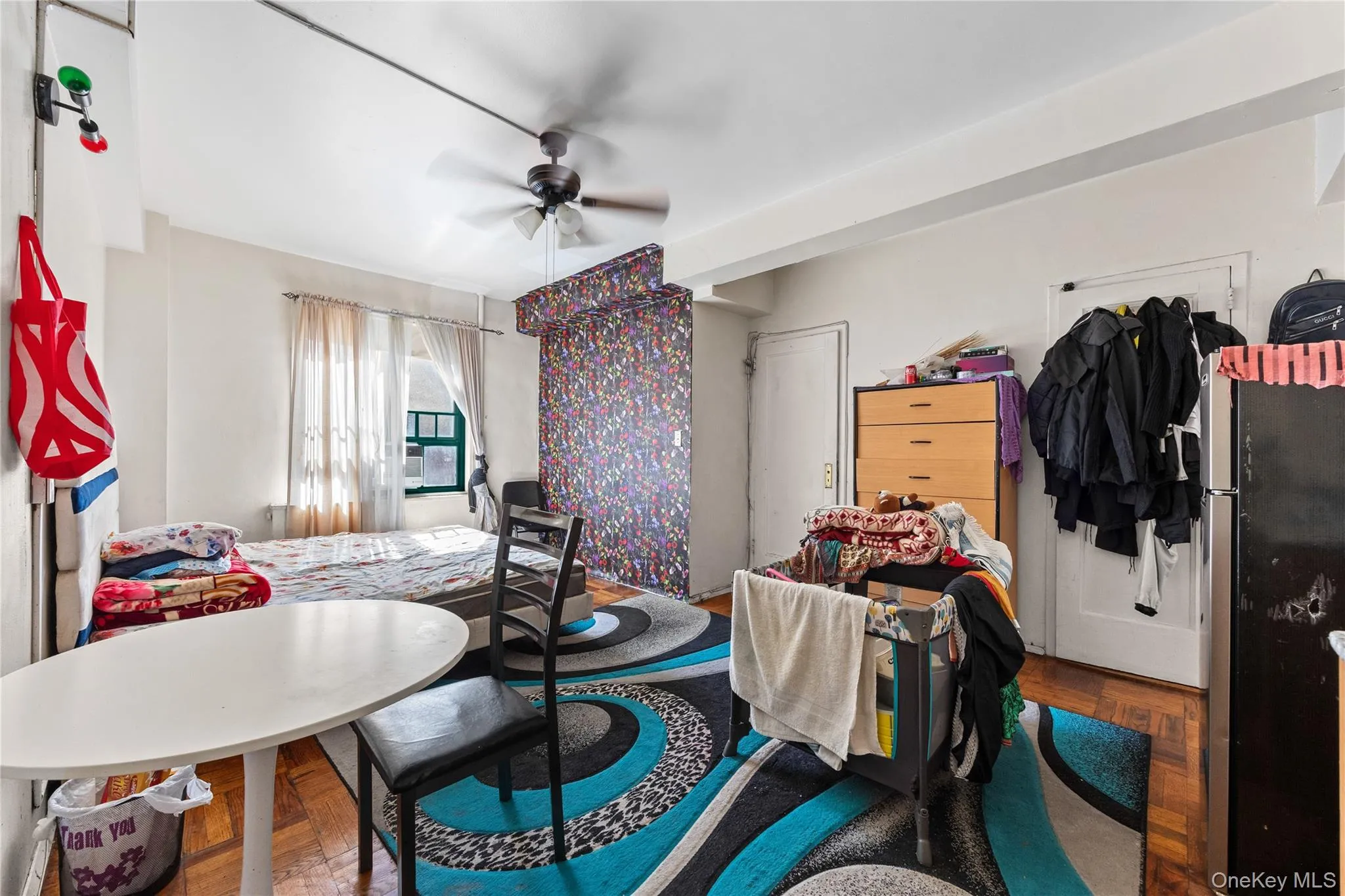 Parquet flooring, ceiling fan with integrated lighting, windowed wall, and accent wall detailing Parquet flooring, ceiling fan with integrated lighting, windowed wall, and accent wall detailing