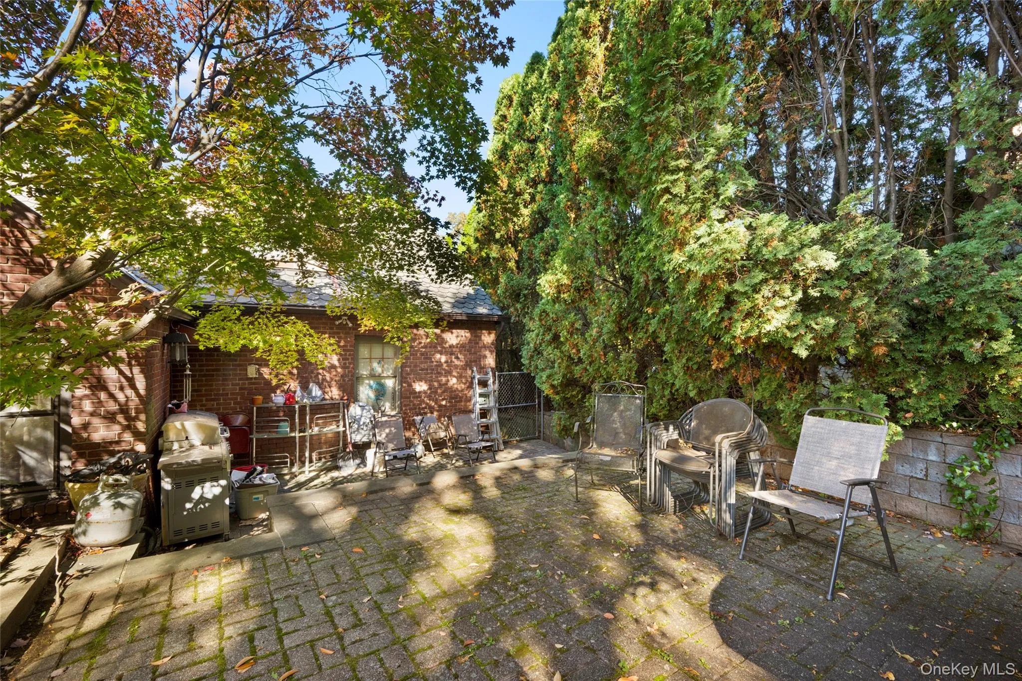 Patio featuring concrete pavers, exterior brick masonry, and mature tree landscaping Patio featuring concrete pavers, exterior brick masonry, and mature tree landscaping