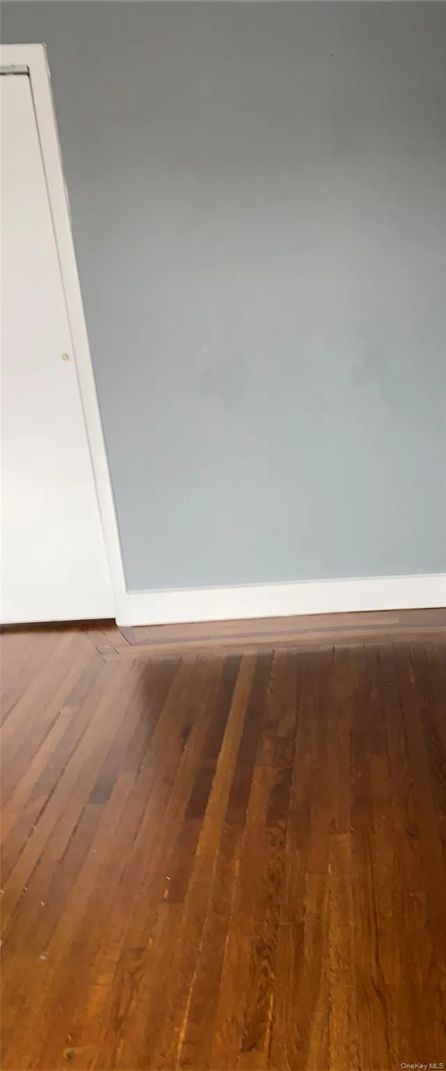 Spare room featuring hardwood / wood-style floors and baseboards Spare room featuring hardwood / wood-style floors and baseboards