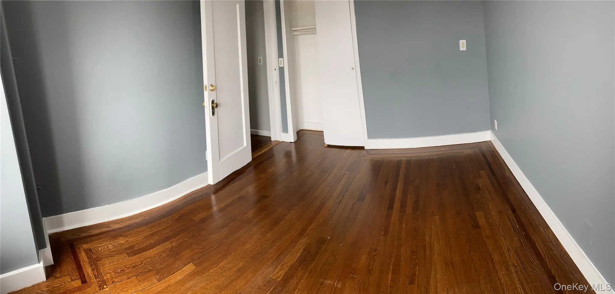 Unfurnished room with baseboards and hardwood / wood-style flooring Unfurnished room with baseboards and hardwood / wood-style flooring