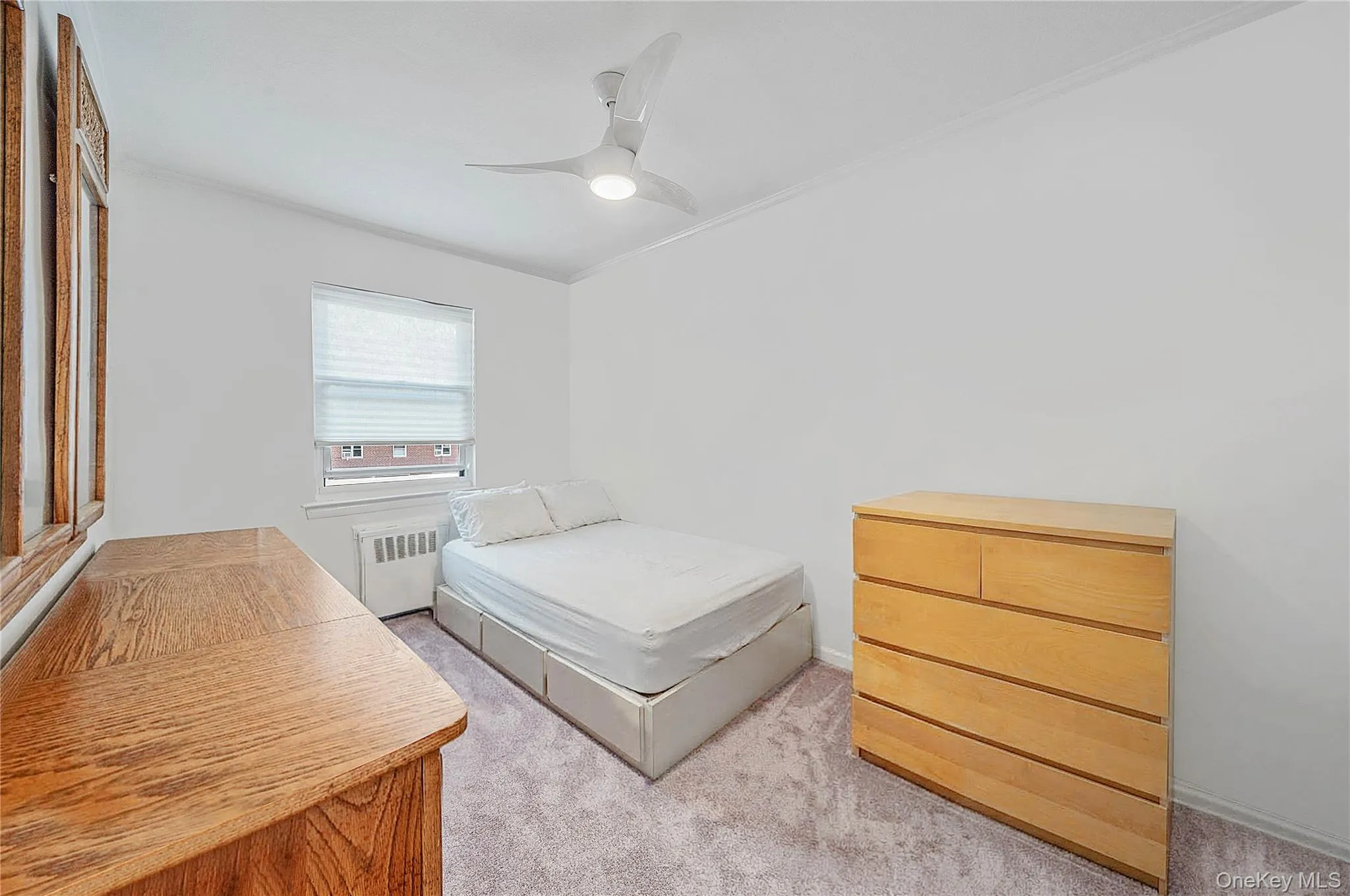 Room featuring neutral wall finishes, carpeted flooring, a ceiling fan with integrated lighting, and a single-pane window with cellular shade Room featuring neutral wall finishes, carpeted flooring, a ceiling fan with integrated lighting, and a single-pane window with cellular shade