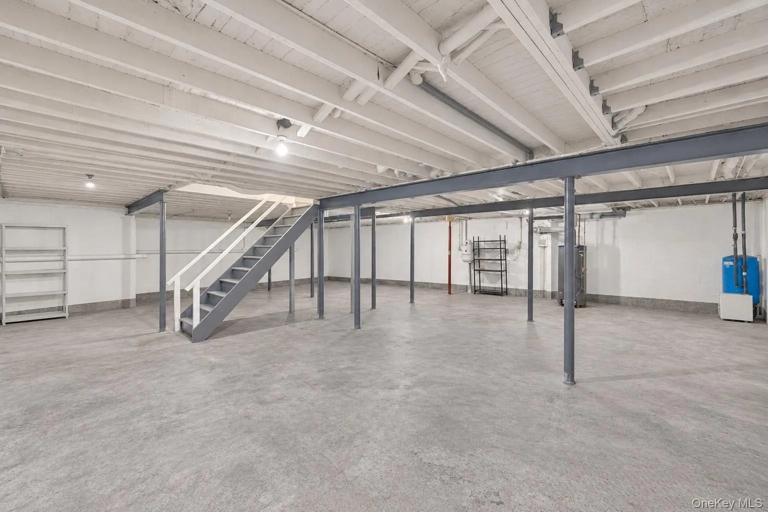 Unfinished basement with 9 ft ceilings. Open-concept lower level featuring exposed ceiling joists, concrete flooring, steel support beams, and painted walls Unfinished basement with 9 ft ceilings. Open-concept lower level featuring exposed ceiling joists, concrete flooring, steel support beams, and painted walls