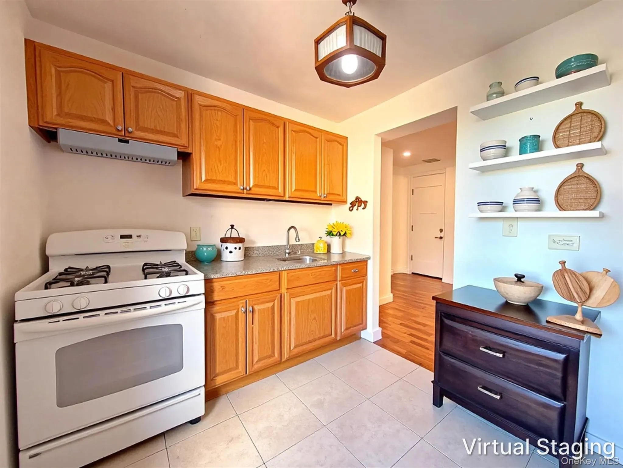 Kitchen featuring wood cabinetry, stone-finish countertops, stainless steel sink, four-burner gas range, and wall-mounted shelving Kitchen featuring wood cabinetry, stone-finish countertops, stainless steel sink, four-burner gas range, and wall-mounted shelving
