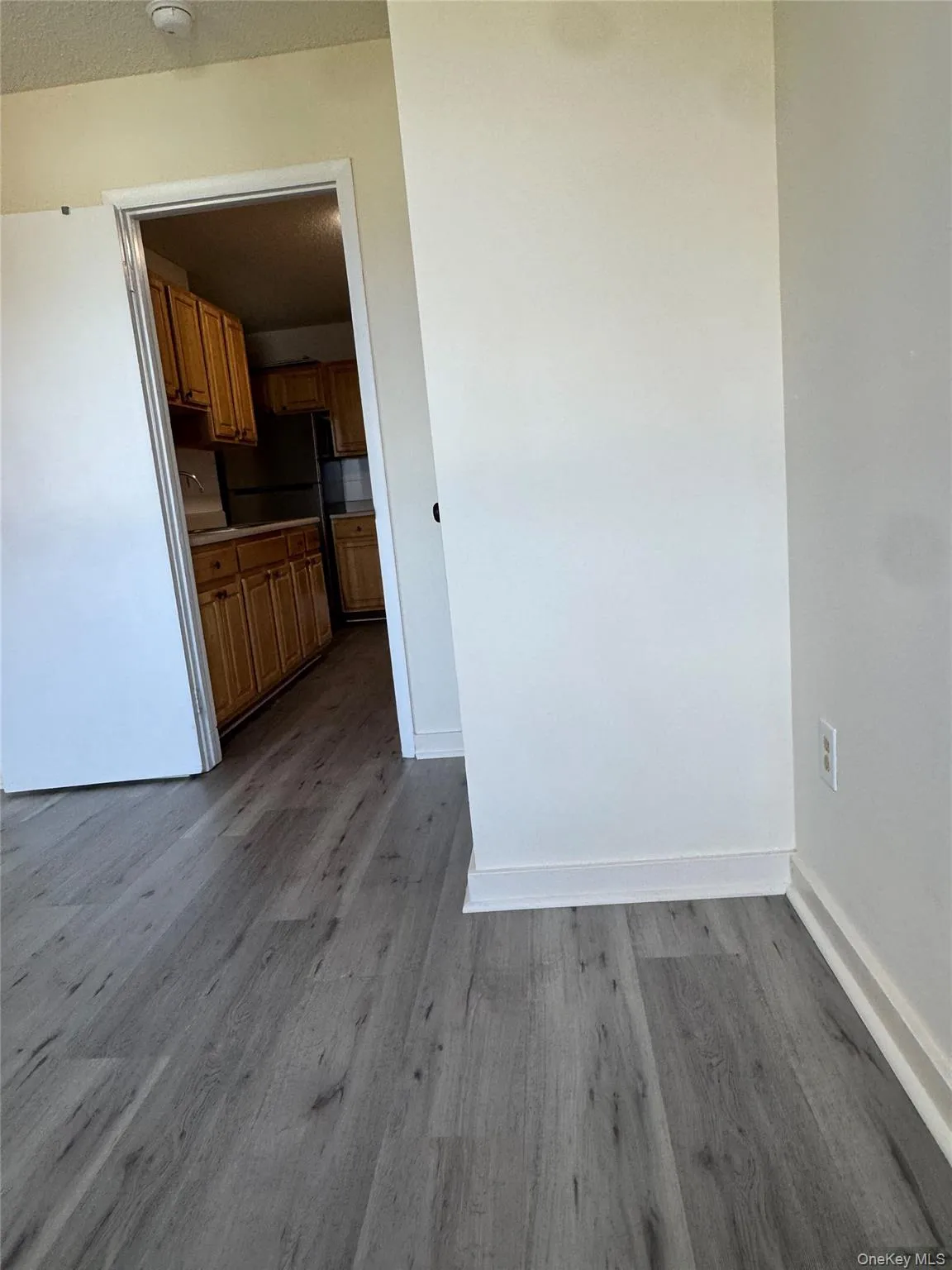 Unfurnished dining area with dark wood-type flooring and baseboards Unfurnished dining area with dark wood-type flooring and baseboards