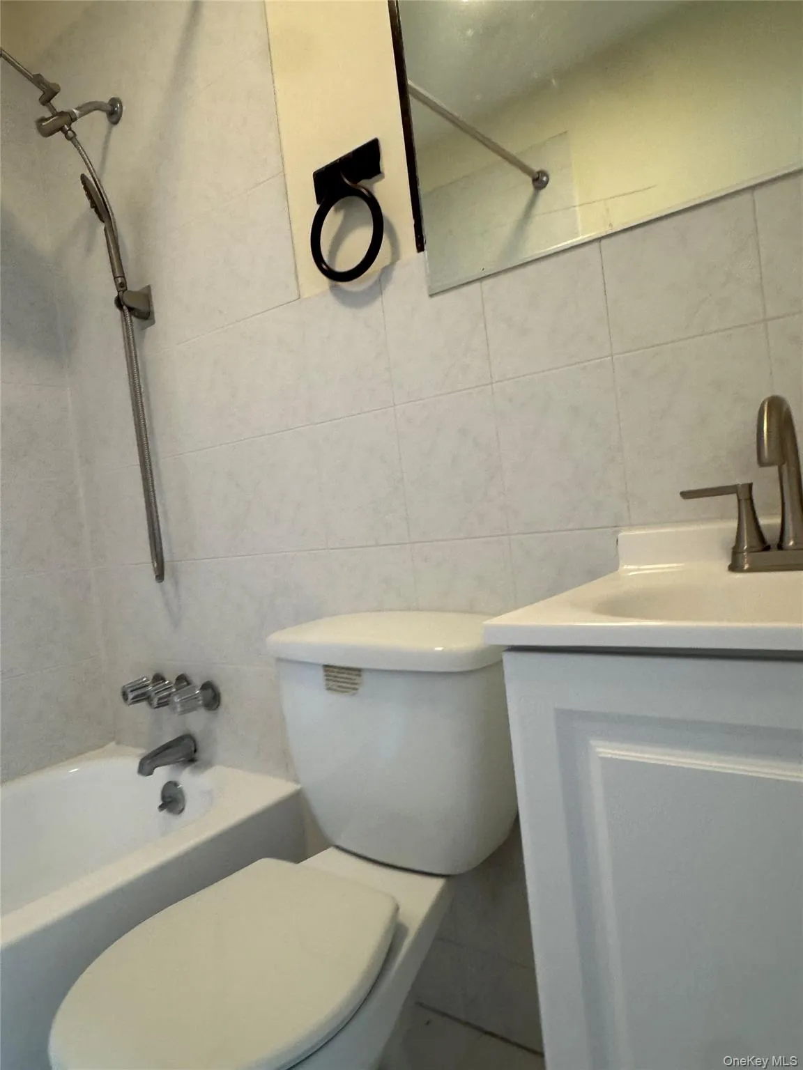 Bathroom with tile walls, shower / bathtub combination, and vanity Bathroom with tile walls, shower / bathtub combination, and vanity