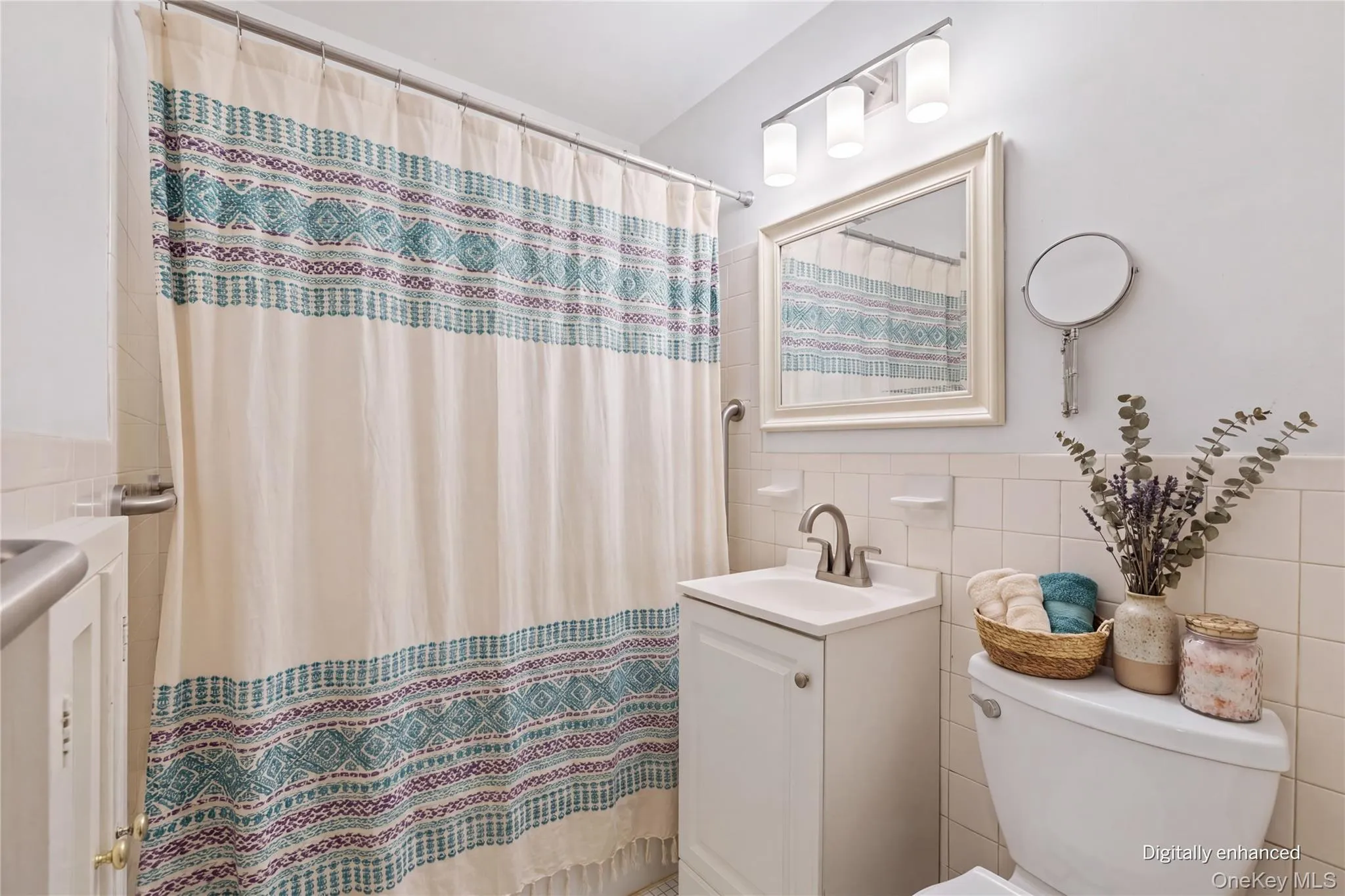 Bathroom Virtually Staged with shower curtain, new mirror and light fixture, added decor. Bathroom Virtually Staged with shower curtain, new mirror and light fixture, added decor.