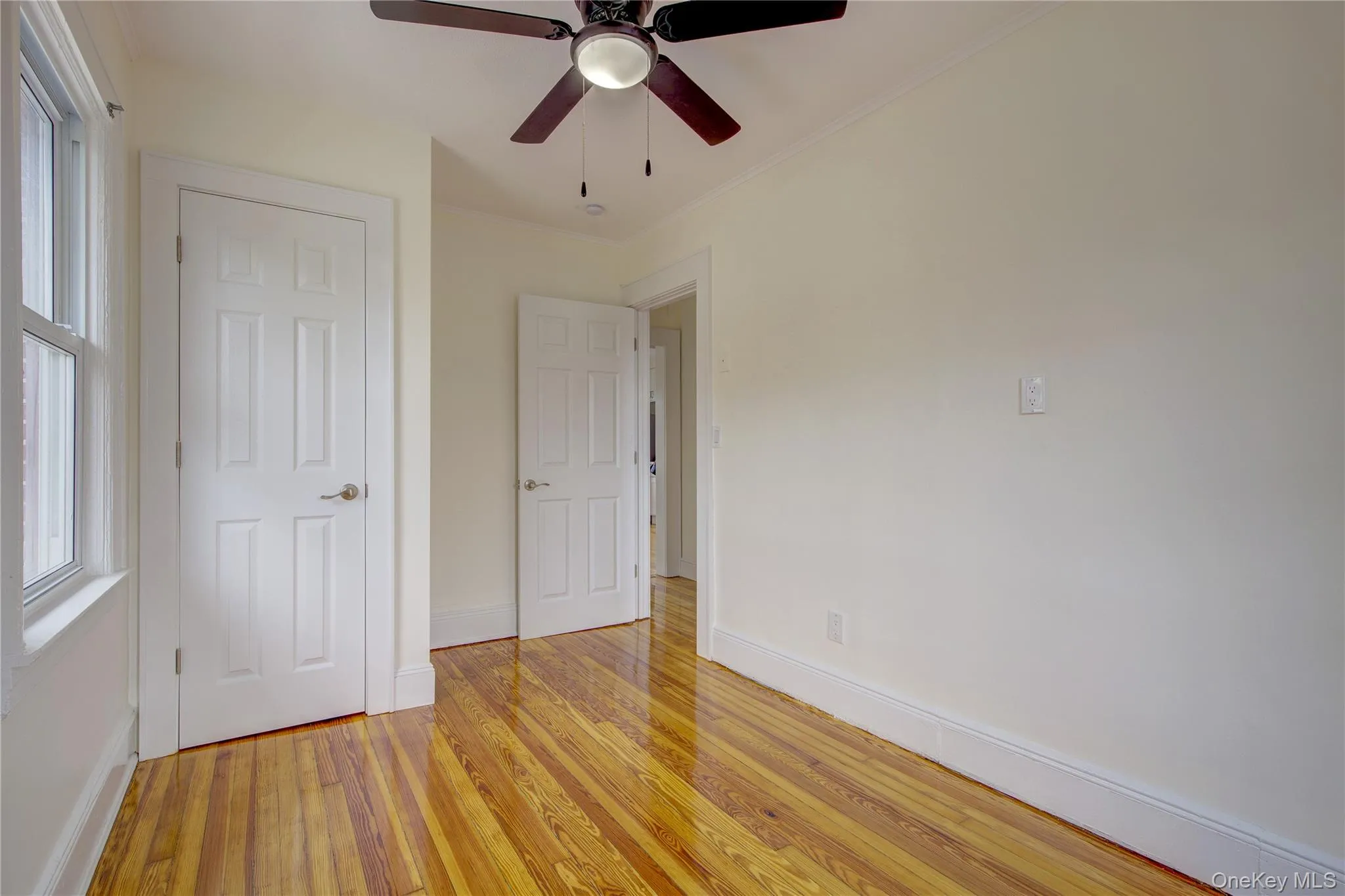 Unfurnished bedroom featuring light wood finished floors, multiple windows, and baseboards Unfurnished bedroom featuring light wood finished floors, multiple windows, and baseboards