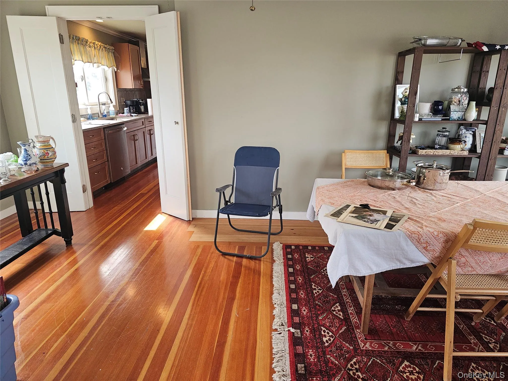 Wood-finish flooring, double-door entryway, and kitchen featuring wood cabinetry and an under-mount sink Wood-finish flooring, double-door entryway, and kitchen featuring wood cabinetry and an under-mount sink