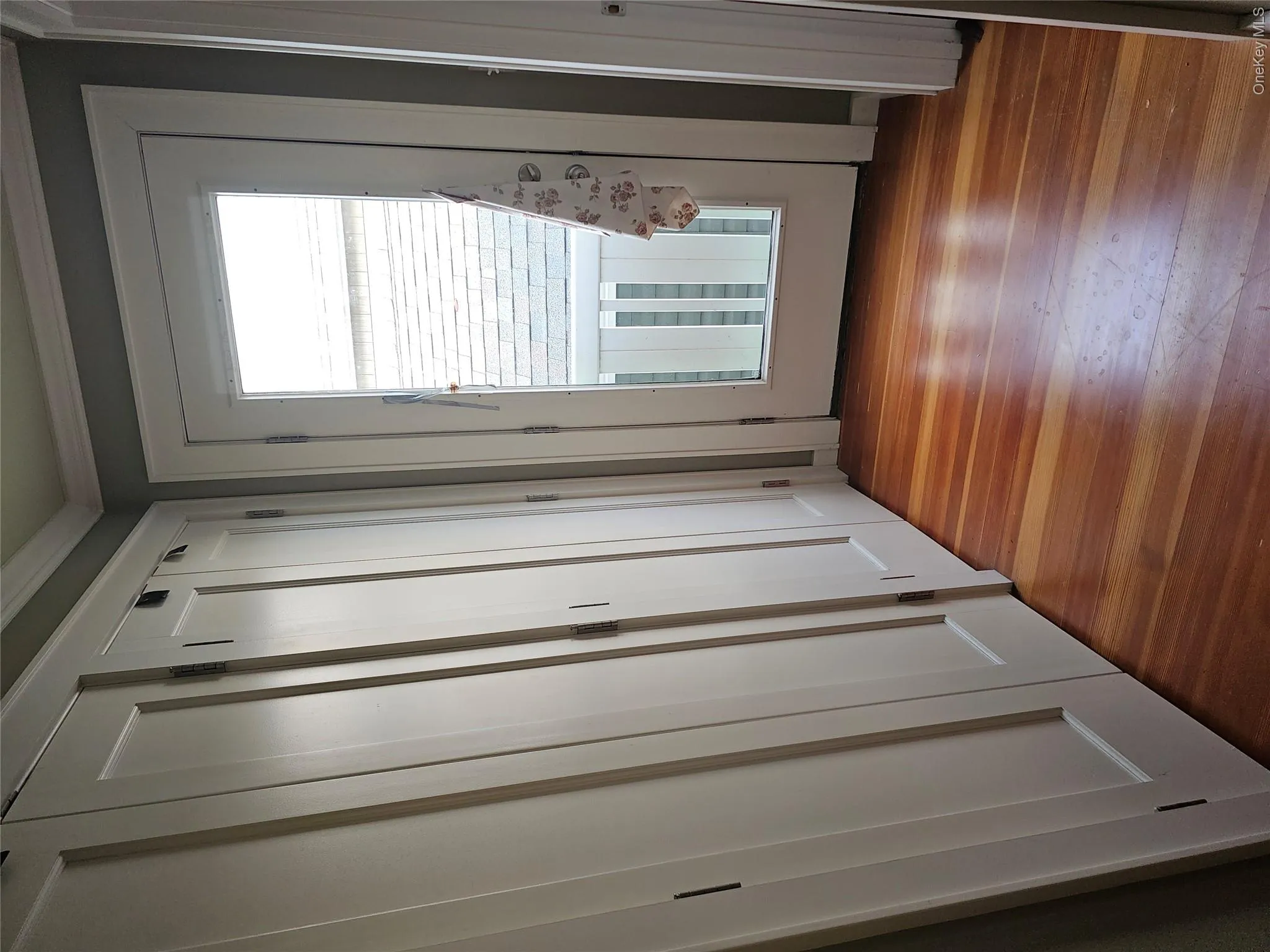 Built-in shaker-style cabinetry, wood-finish flooring, and a glass-panel exterior door with white trim Built-in shaker-style cabinetry, wood-finish flooring, and a glass-panel exterior door with white trim