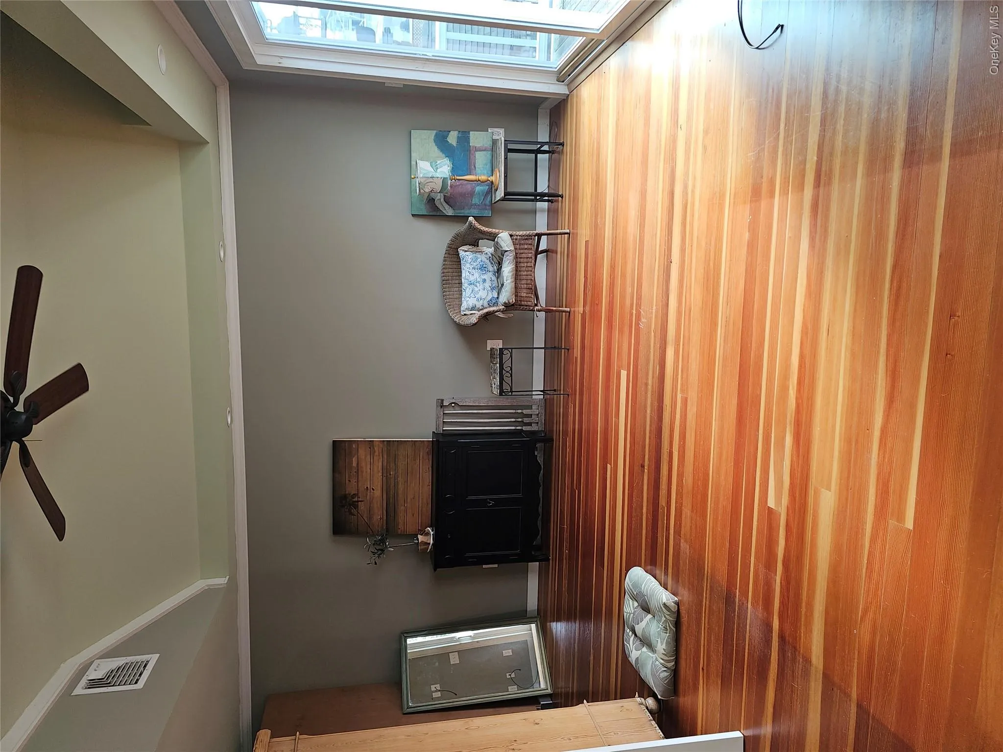 Vaulted ceiling featuring a central paddle fan, wood-finish flooring, and glass sliding doors Vaulted ceiling featuring a central paddle fan, wood-finish flooring, and glass sliding doors