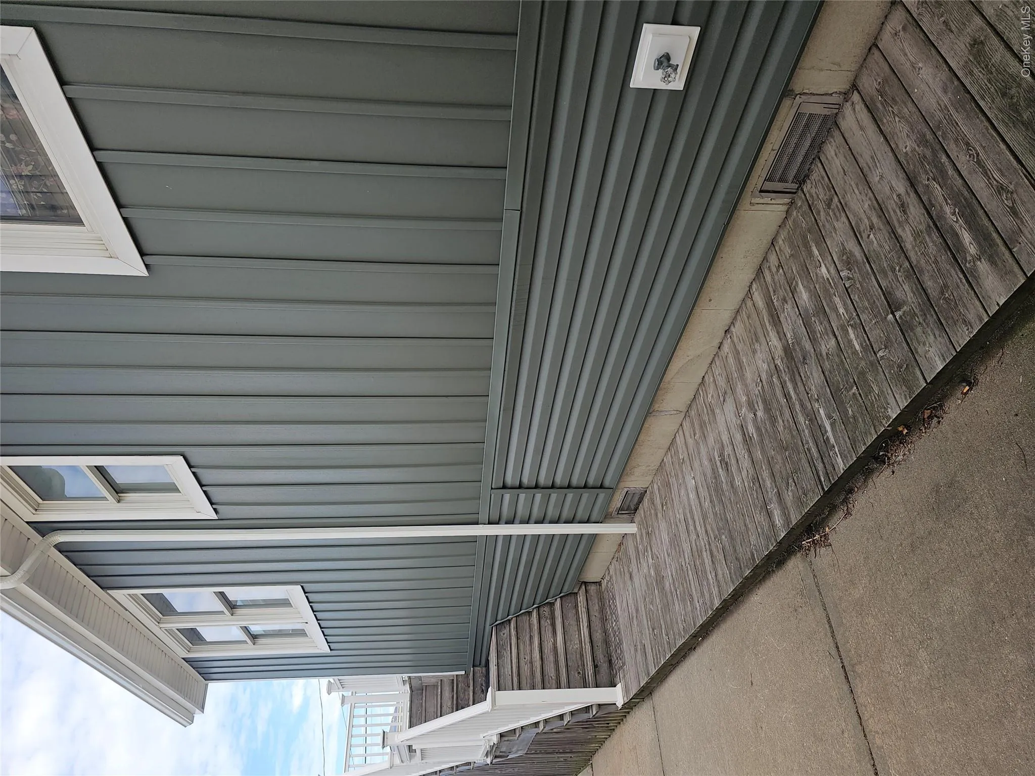 Exterior featuring board-and-batten and horizontal lap siding, white trim, wood-plank decking, and a white railing system Exterior featuring board-and-batten and horizontal lap siding, white trim, wood-plank decking, and a white railing system