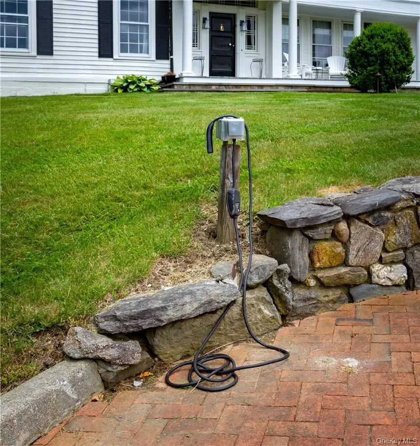 Outlet for an electric charger (charger not supplied) in the driveway. Outlet for an electric charger (charger not supplied) in the driveway.