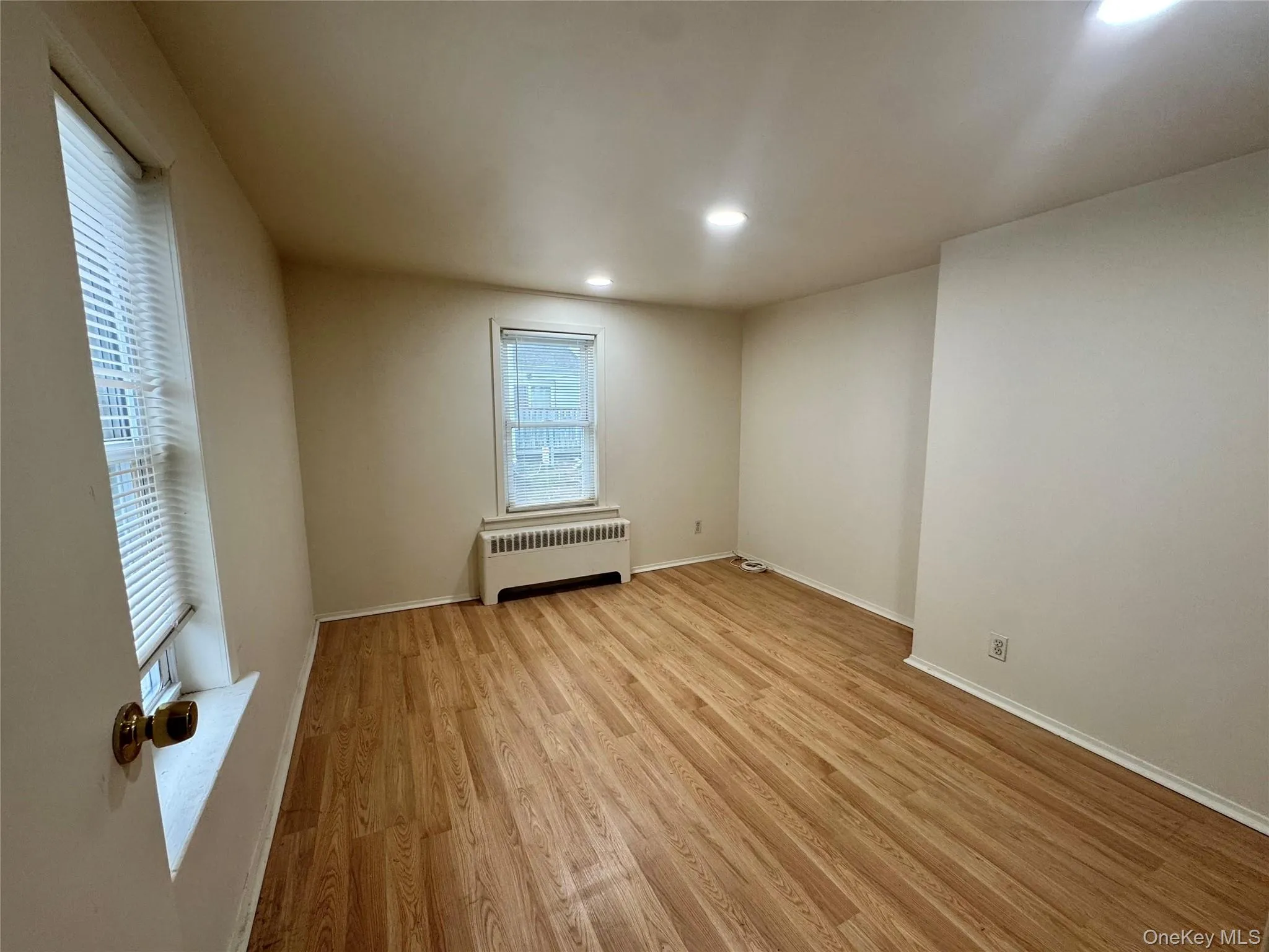 Interior space featuring wood-finish flooring, neutral wall paint, recessed lighting, and multiple windows Interior space featuring wood-finish flooring, neutral wall paint, recessed lighting, and multiple windows