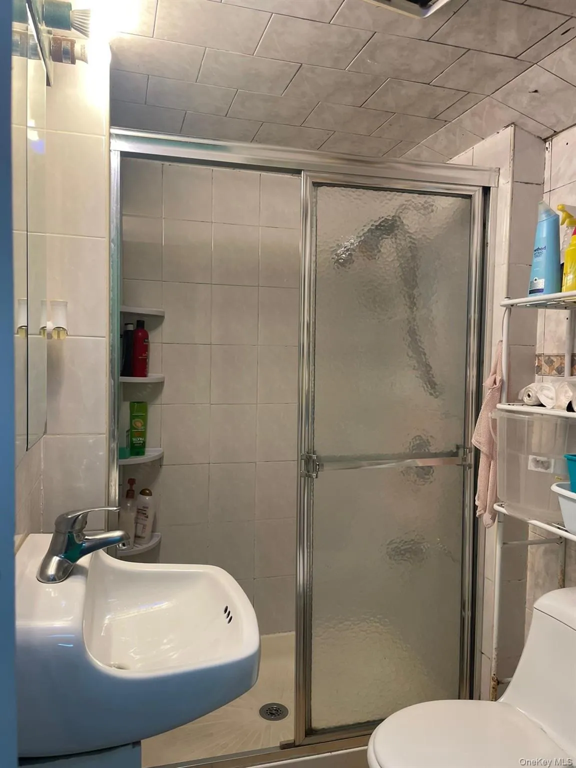 Full bath with a sink, tile walls, and toilet Full bath with a sink, tile walls, and toilet