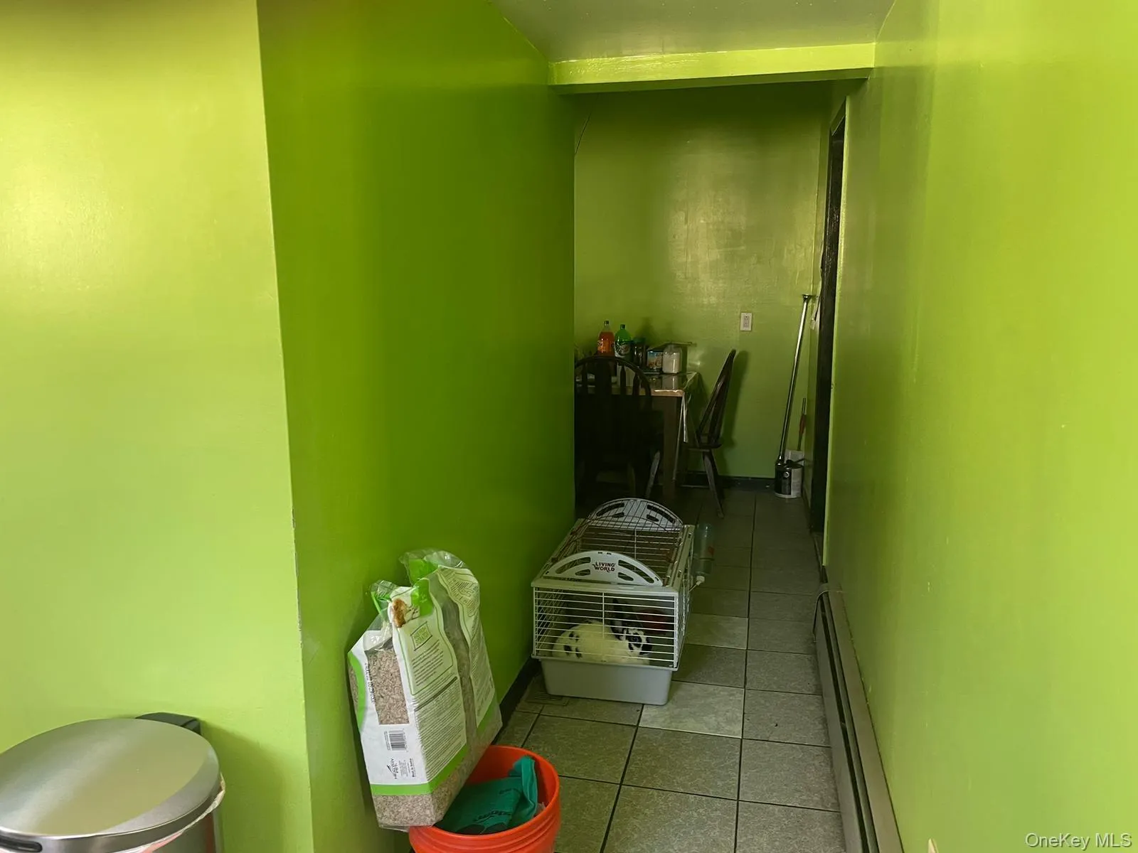 Corridor with a baseboard radiator, tile patterned flooring, and baseboards Corridor with a baseboard radiator, tile patterned flooring, and baseboards