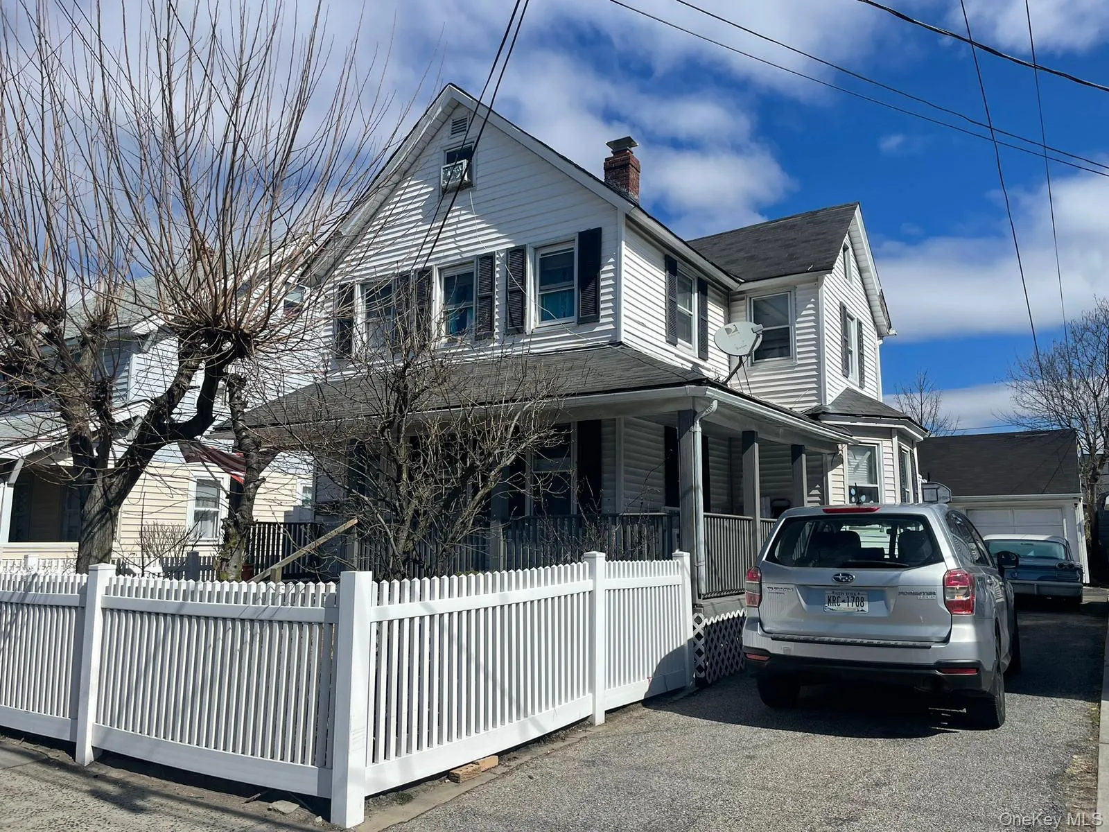 View of property exterior with covered porch, a chimney, and a fenced front yard View of property exterior with covered porch, a chimney, and a fenced front yard