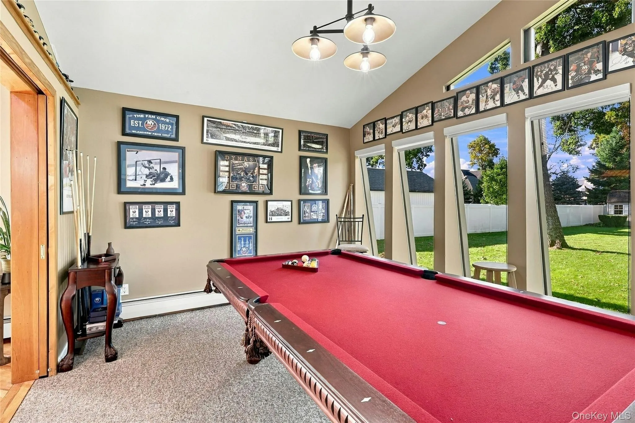 Vaulted ceiling featuring a multi-bulb pendant light, expansive floor-to-ceiling windows, and wall-to-wall carpeting Vaulted ceiling featuring a multi-bulb pendant light, expansive floor-to-ceiling windows, and wall-to-wall carpeting