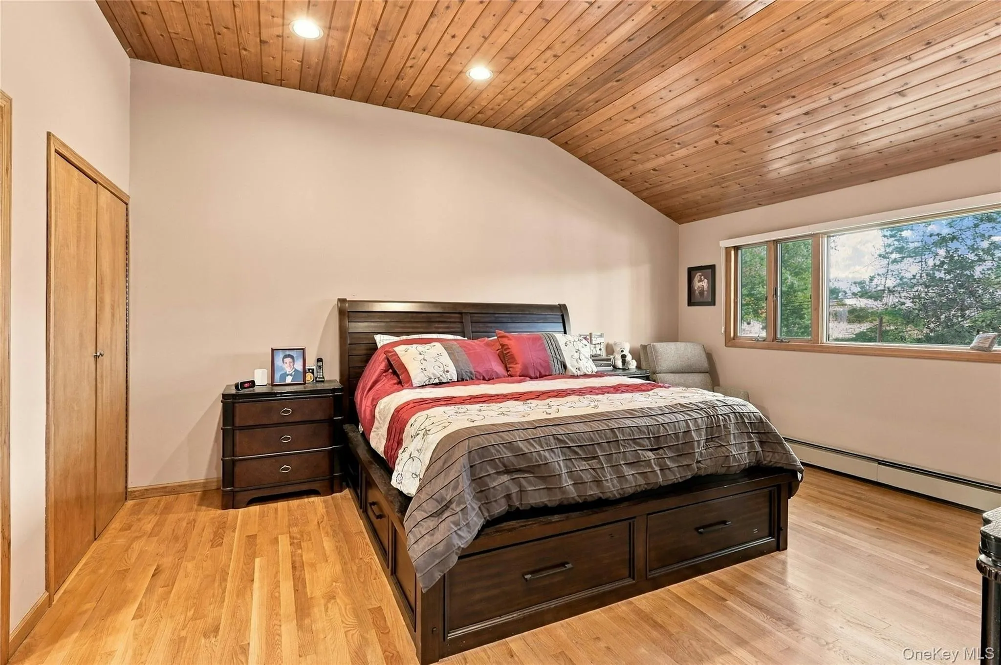 Vaulted wood-plank ceiling featuring recessed lighting, natural wood-finish flooring, and built-in closet with wood doors Vaulted wood-plank ceiling featuring recessed lighting, natural wood-finish flooring, and built-in closet with wood doors