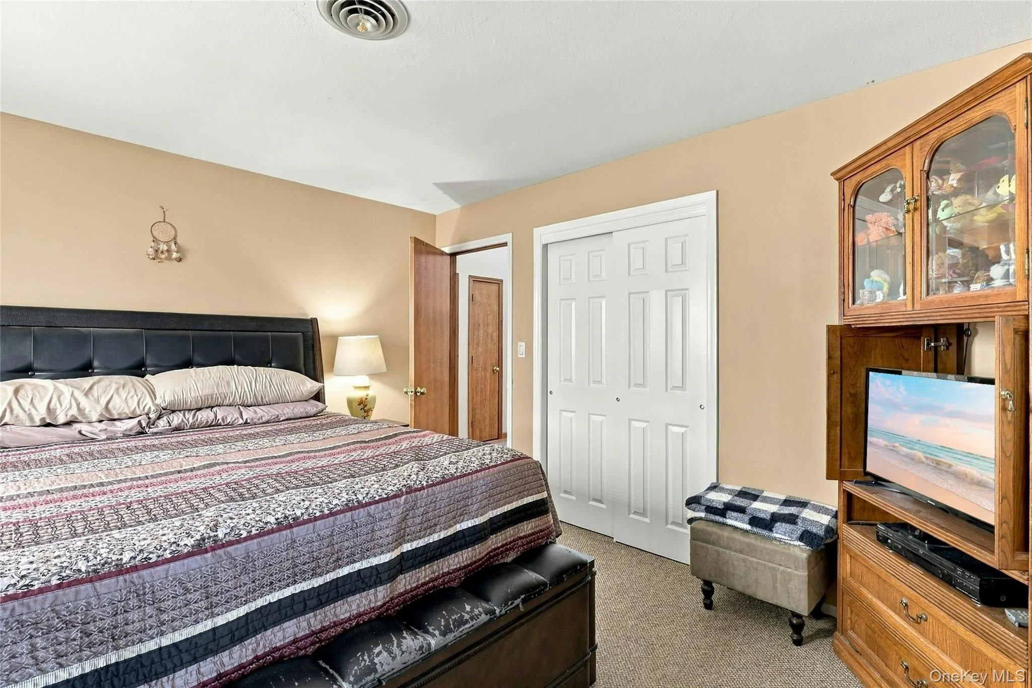 Neutral wall tones, carpeted flooring, and double-panel sliding closet doors with white trim Neutral wall tones, carpeted flooring, and double-panel sliding closet doors with white trim