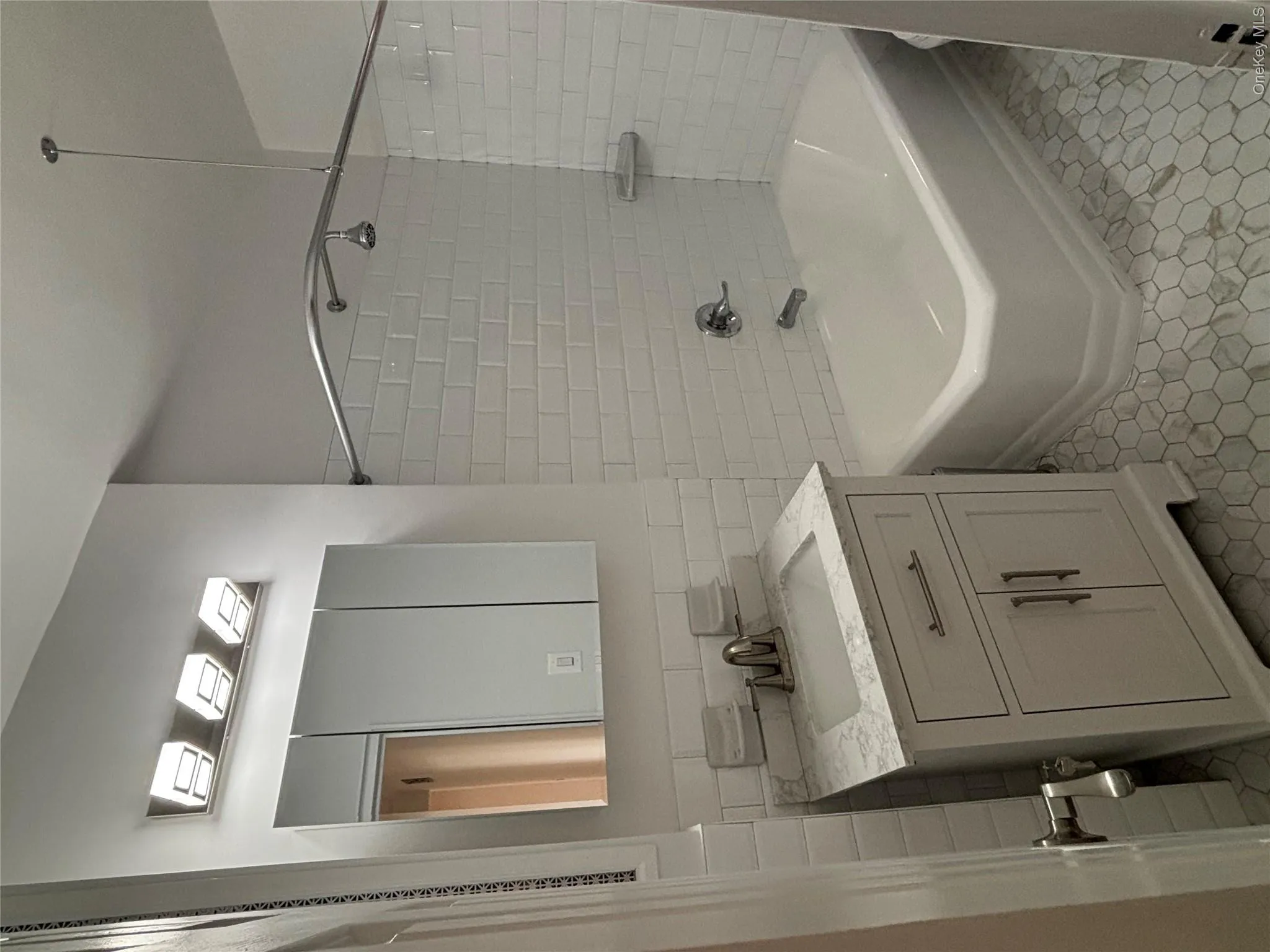 Bathroom featuring vanity, shower / washtub combination, tile walls, and light tile patterned floors Bathroom featuring vanity, shower / washtub combination, tile walls, and light tile patterned floors