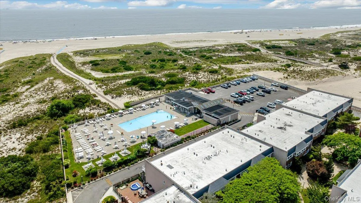 Birds eye view of property featuring a water view and a view of the beach Birds eye view of property featuring a water view and a view of the beach