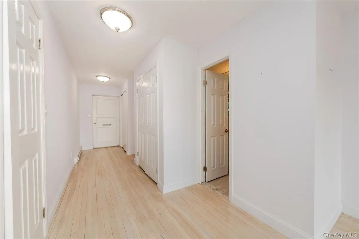 Hallway featuring light wood-style flooring and baseboards Hallway featuring light wood-style flooring and baseboards