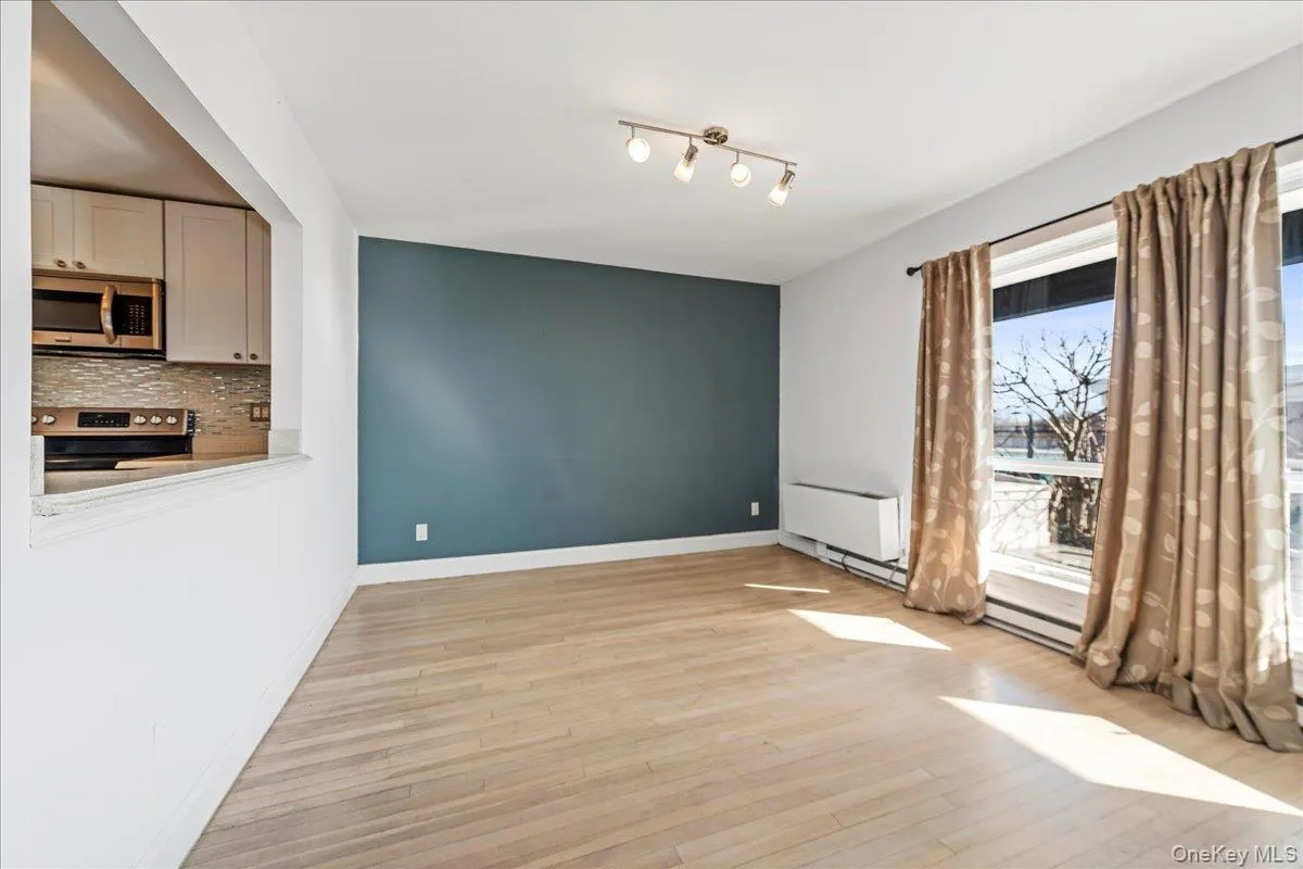 Unfurnished dining area featuring light wood-style flooring and baseboards Unfurnished dining area featuring light wood-style flooring and baseboards