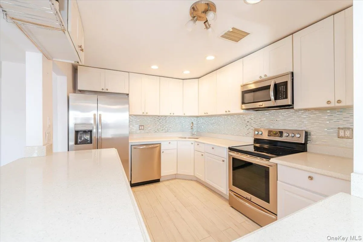 Kitchen featuring a sink, visible vents, white cabinets, and stainless steel appliances Kitchen featuring a sink, visible vents, white cabinets, and stainless steel appliances