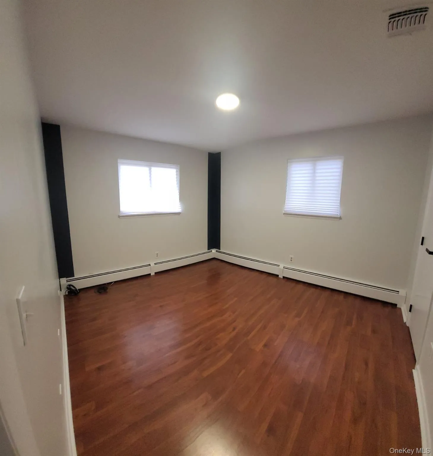 Empty room featuring dark hardwood / wood-style flooring Empty room featuring dark hardwood / wood-style flooring