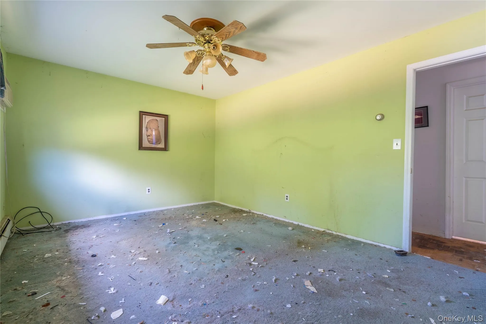 Room featuring a five-blade ceiling fan with integrated light fixture and a multi-panel interior door Room featuring a five-blade ceiling fan with integrated light fixture and a multi-panel interior door