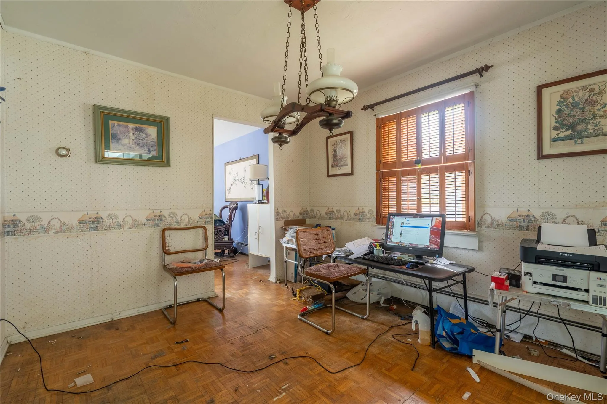 Parquet wood-finish flooring, decorative multi-light chandelier, and wooden louvered window shutters Parquet wood-finish flooring, decorative multi-light chandelier, and wooden louvered window shutters