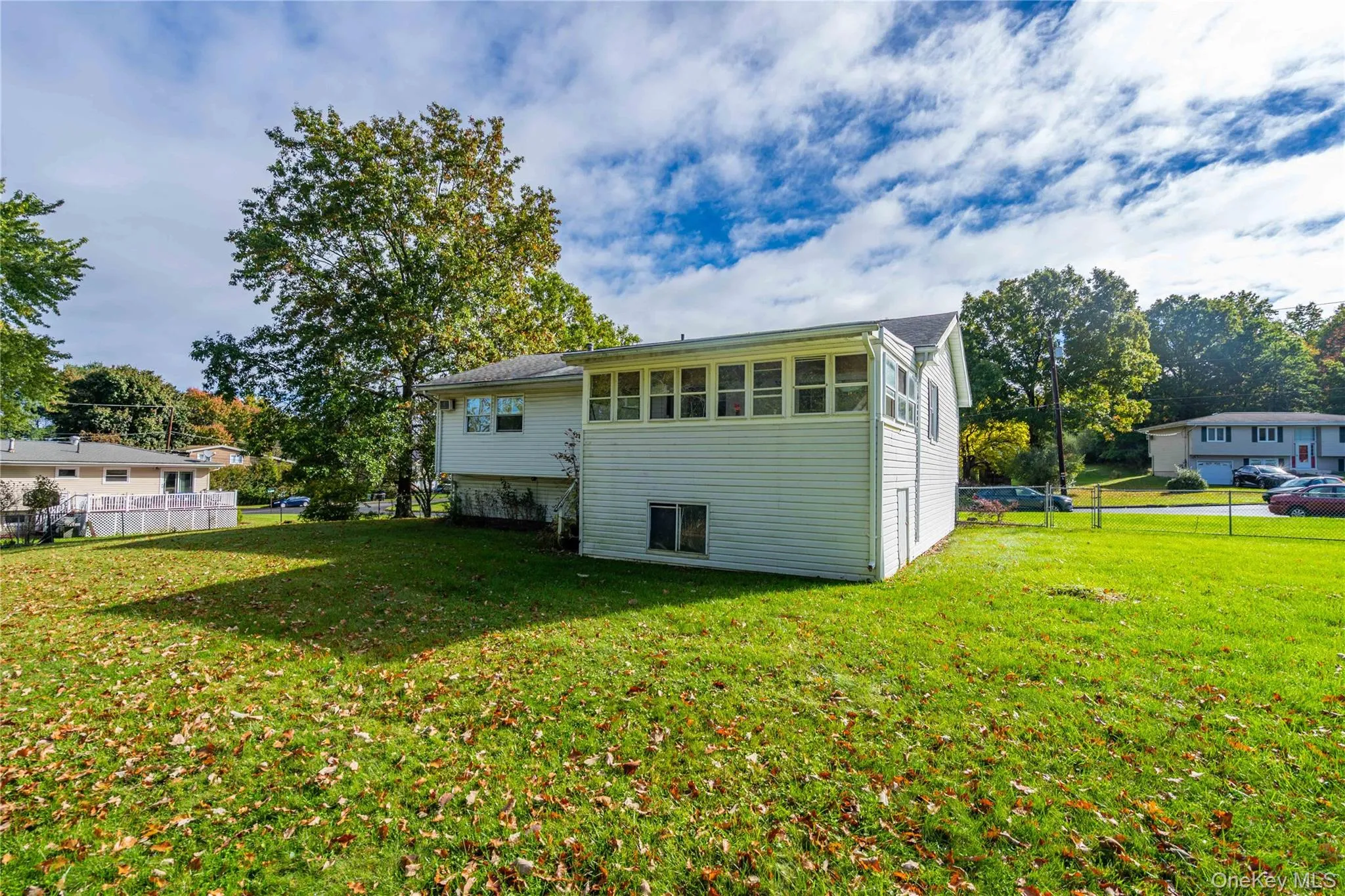 Exterior featuring horizontal siding, a multi-window enclosed sunroom, and an expansive lawn Exterior featuring horizontal siding, a multi-window enclosed sunroom, and an expansive lawn