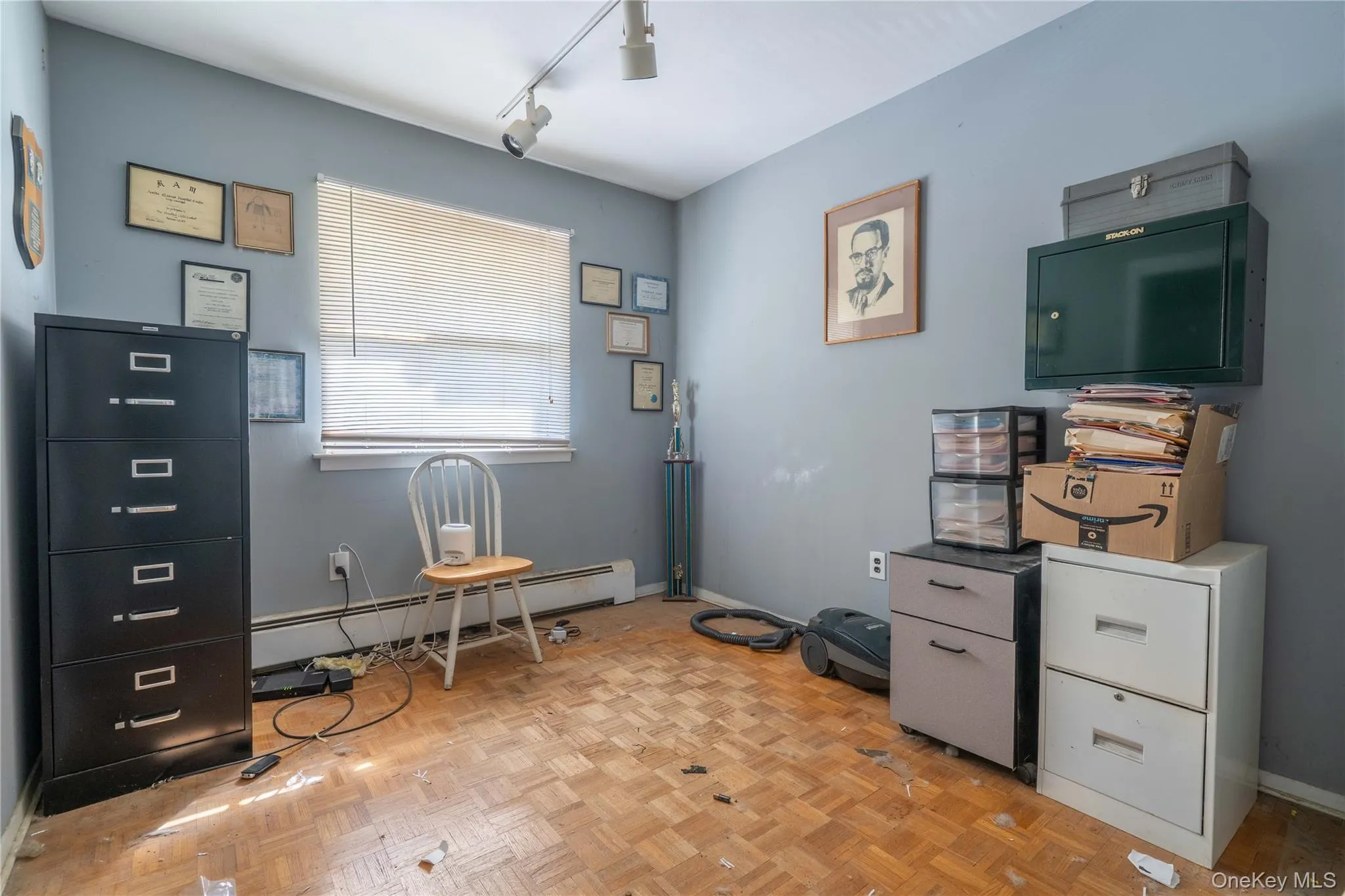 Parquet wood-finish flooring, multi-directional track lighting, and a window with integrated blinds Parquet wood-finish flooring, multi-directional track lighting, and a window with integrated blinds