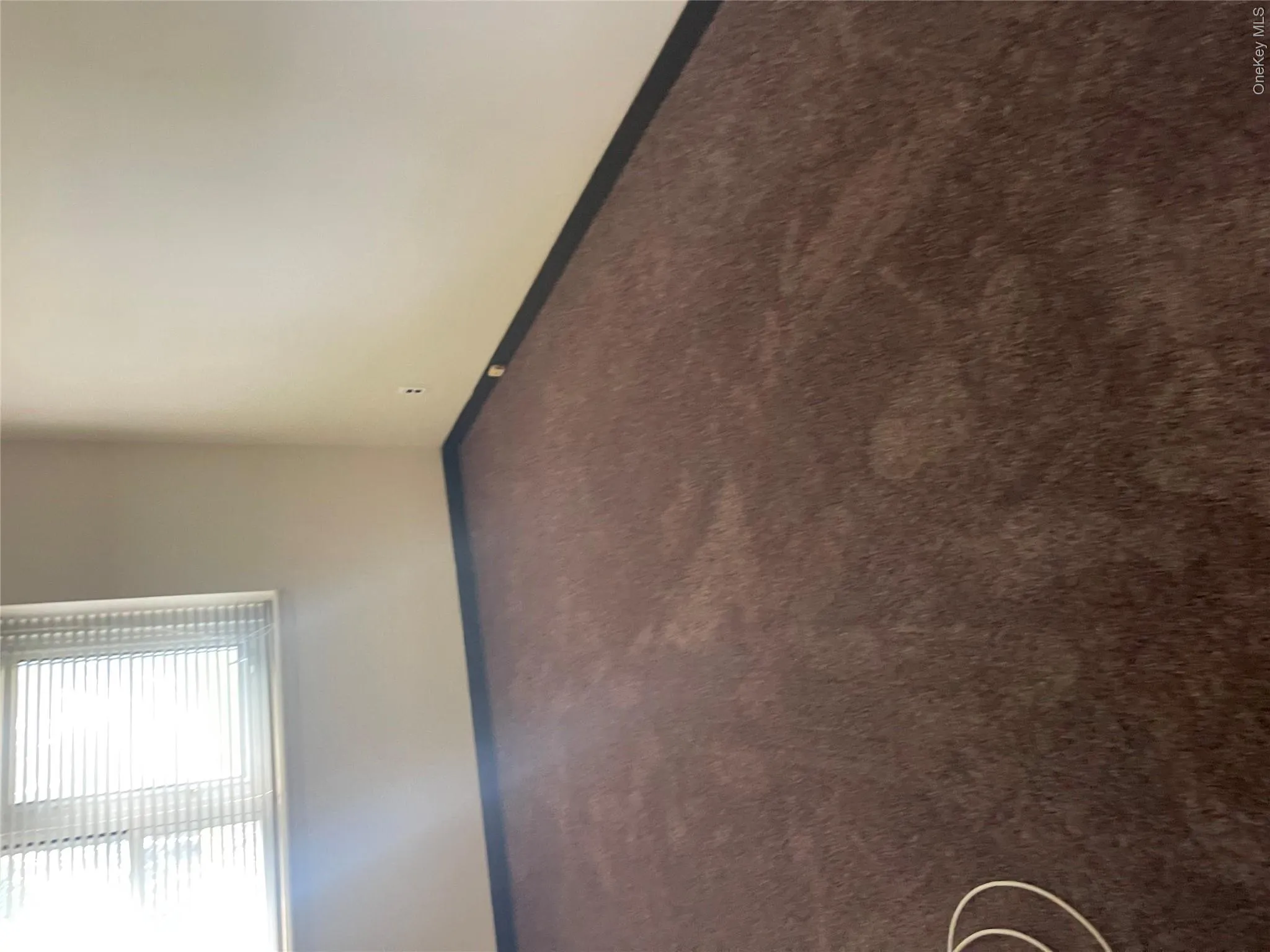 Interior room featuring new wall-to-wall carpeting and a window with installed horizontal blinds Interior room featuring new wall-to-wall carpeting and a window with installed horizontal blinds