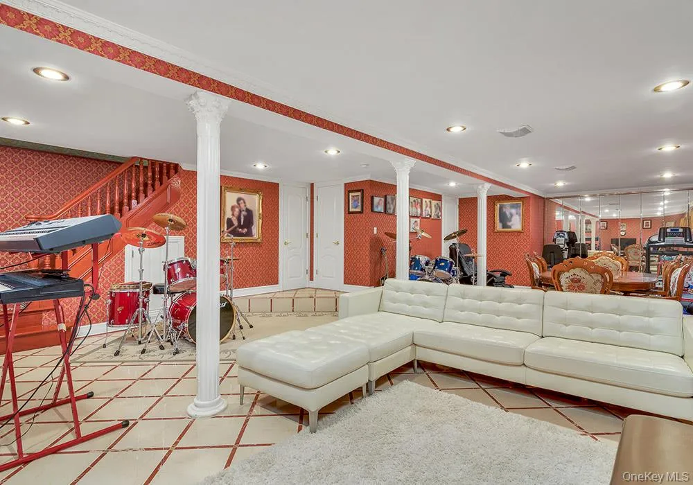 Open-plan room featuring tile flooring, classic columns, recessed lighting, and a mirrored wall Open-plan room featuring tile flooring, classic columns, recessed lighting, and a mirrored wall