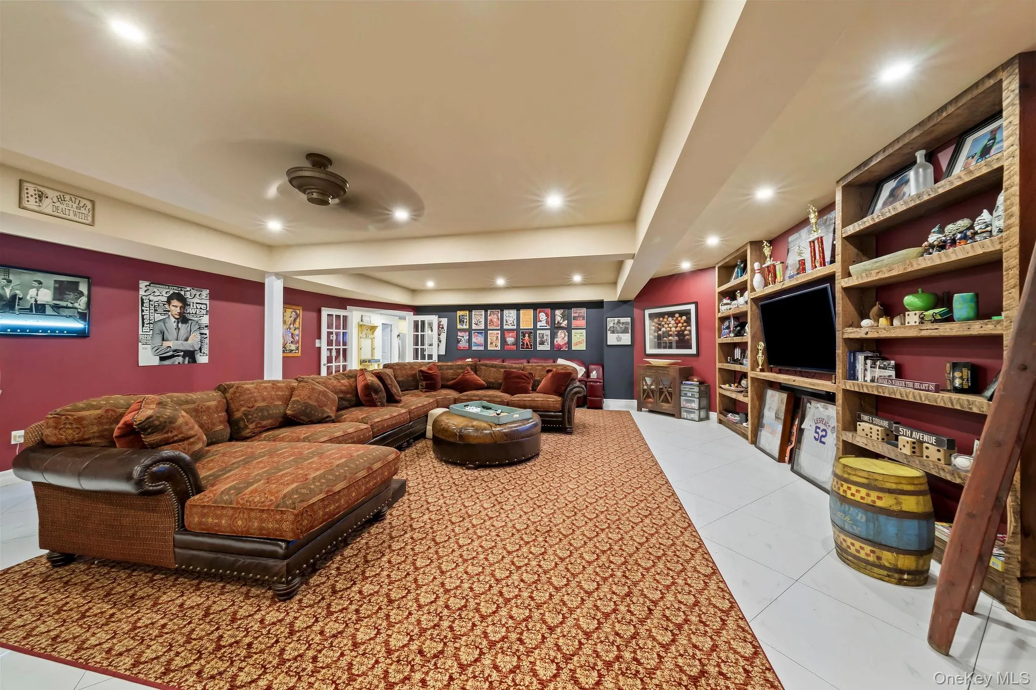 Spacious room featuring floor-to-ceiling built-in wooden shelving, recessed lighting, tile flooring, and French doors Spacious room featuring floor-to-ceiling built-in wooden shelving, recessed lighting, tile flooring, and French doors