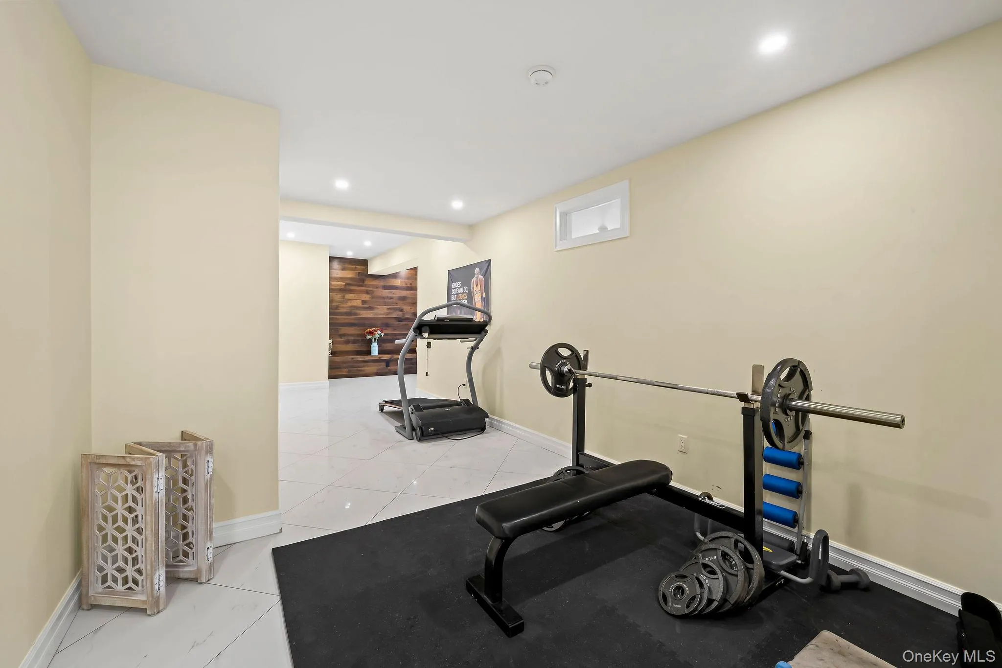 Large-format tile flooring, recessed ceiling lighting, and a prominent wood-panel feature wall Large-format tile flooring, recessed ceiling lighting, and a prominent wood-panel feature wall