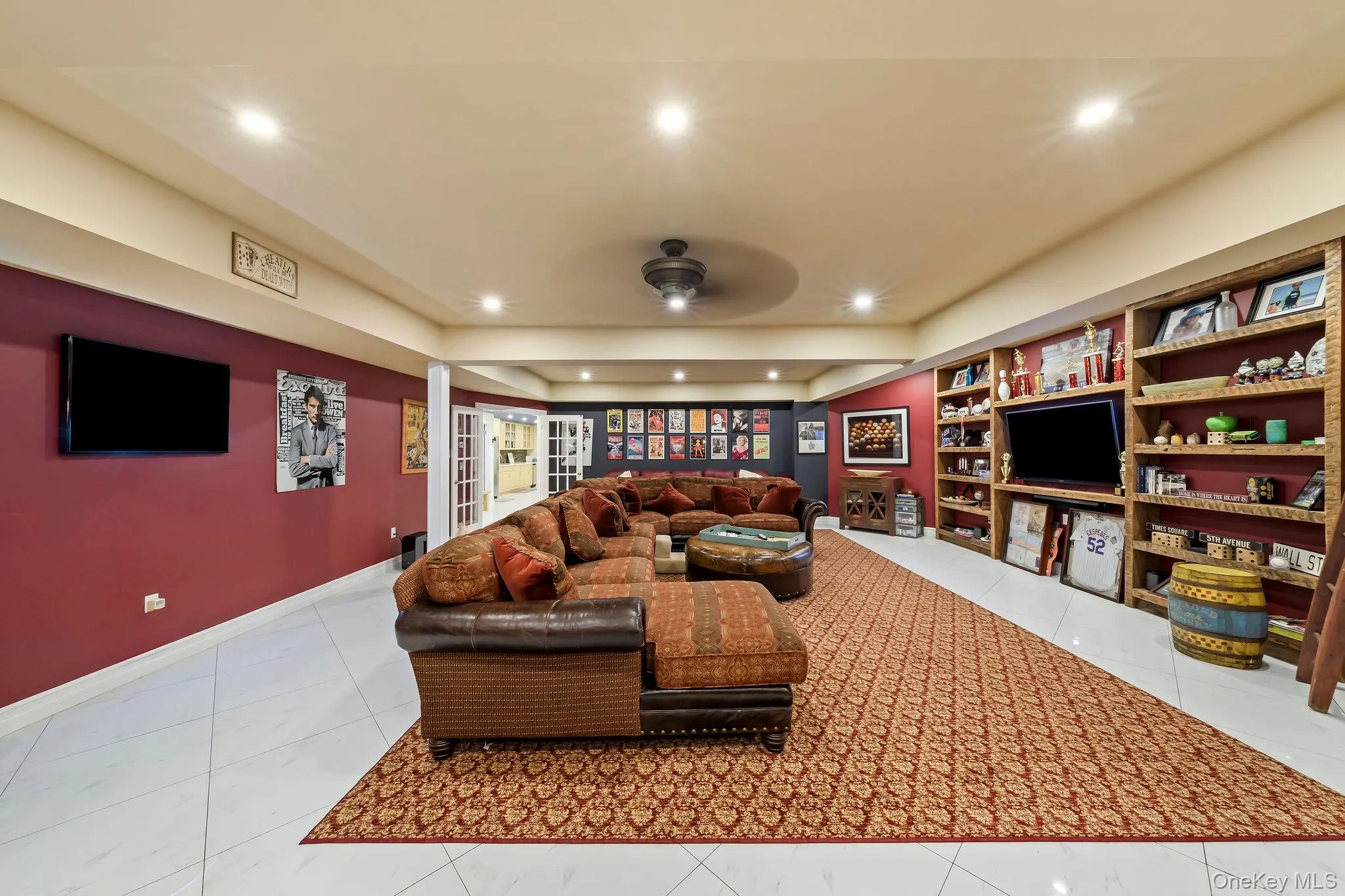 Large recreation space featuring polished tile flooring, recessed lighting, ceiling fan, and extensive built-in wood shelving Large recreation space featuring polished tile flooring, recessed lighting, ceiling fan, and extensive built-in wood shelving