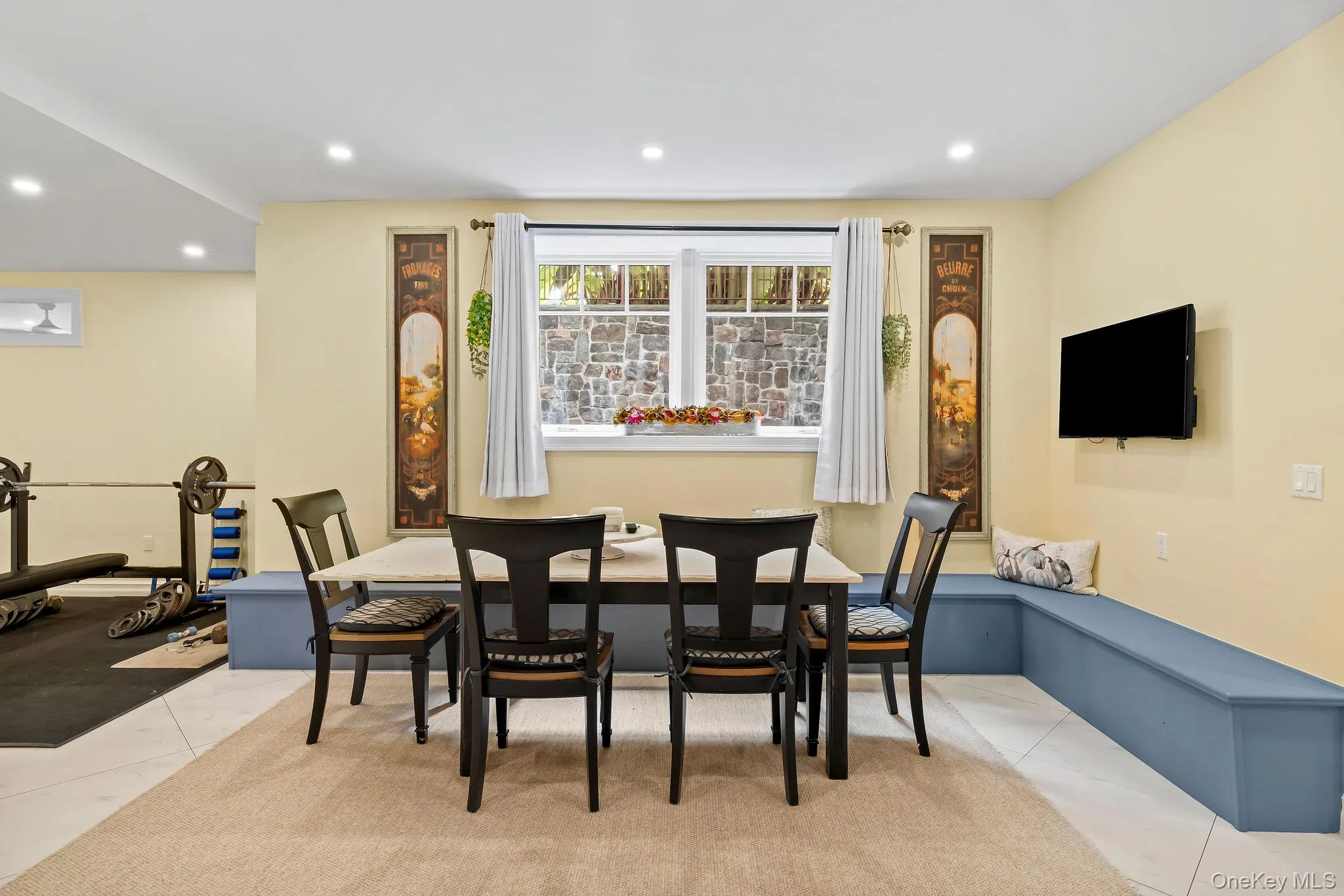 L-shaped built-in bench seating, inset window with stone exterior surround, recessed lighting, and tile flooring L-shaped built-in bench seating, inset window with stone exterior surround, recessed lighting, and tile flooring