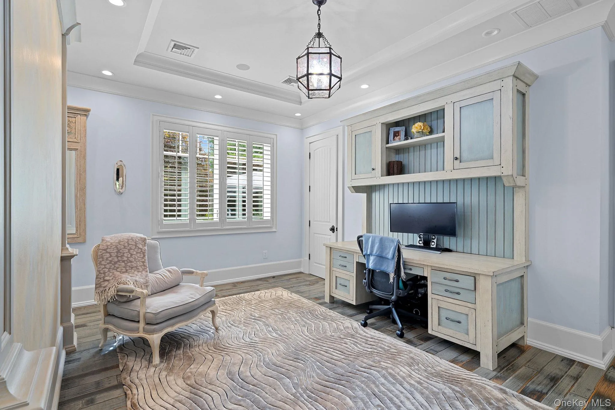 Tray ceiling, built-in cabinetry with beadboard paneling, recessed lighting, polished wood-finish flooring, and plantation shutters Tray ceiling, built-in cabinetry with beadboard paneling, recessed lighting, polished wood-finish flooring, and plantation shutters