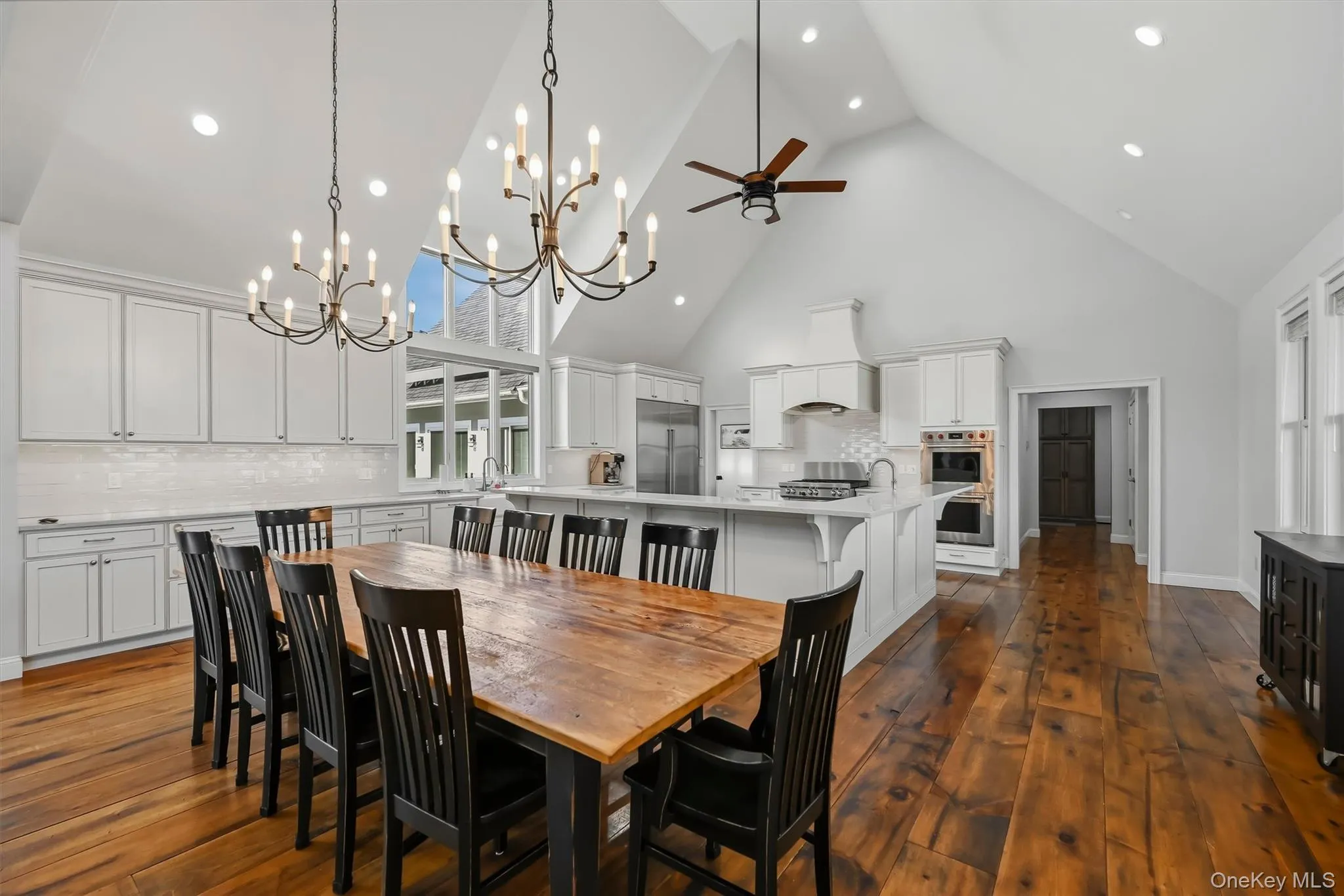 Vaulted ceilings, wood-finish flooring, custom shaker-style cabinetry, stone countertops, and tiered chandelier lighting Vaulted ceilings, wood-finish flooring, custom shaker-style cabinetry, stone countertops, and tiered chandelier lighting