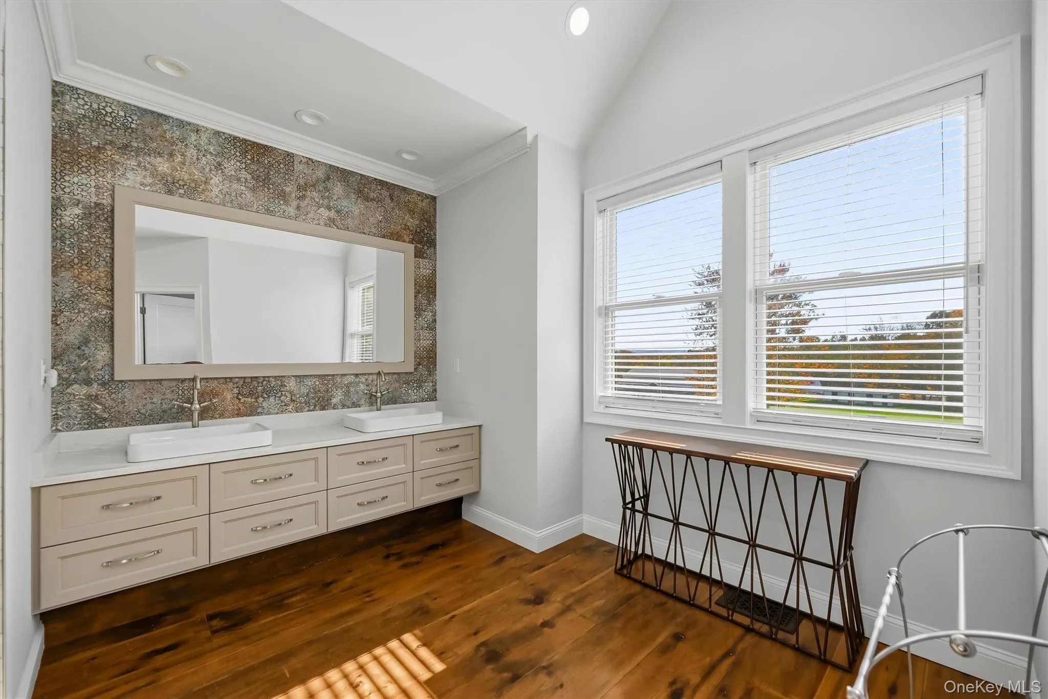 Dual-sink vanity with rectangular vessel basins, quartz countertop, textured mosaic tile backsplash, wood-finish flooring, and vaulted ceiling Dual-sink vanity with rectangular vessel basins, quartz countertop, textured mosaic tile backsplash, wood-finish flooring, and vaulted ceiling
