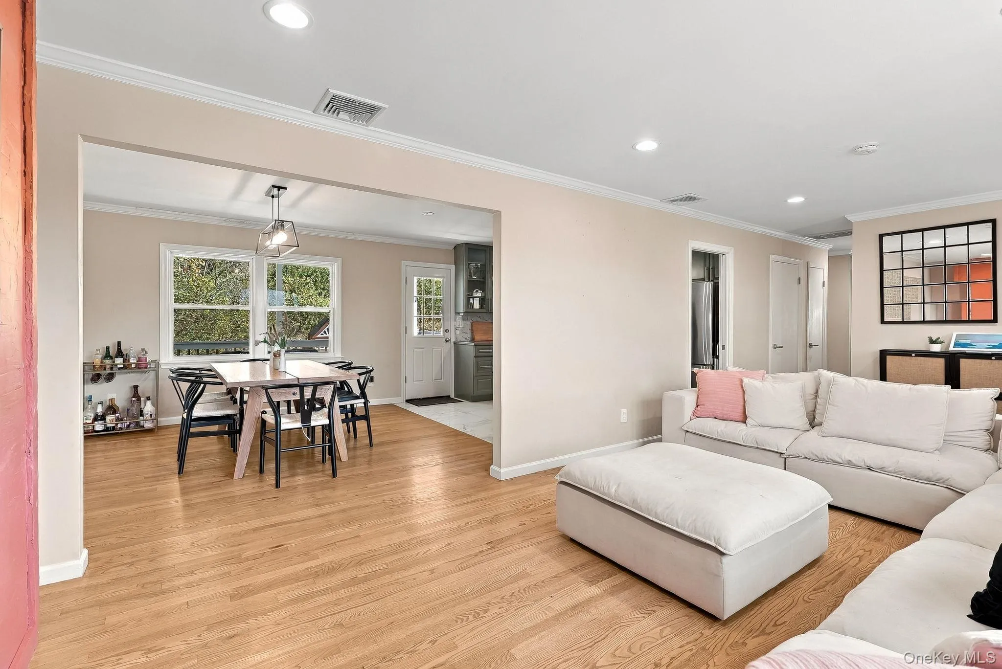 Interior featuring wood-finish flooring, recessed lighting, crown molding, and a grid-pattern wall mirror Interior featuring wood-finish flooring, recessed lighting, crown molding, and a grid-pattern wall mirror