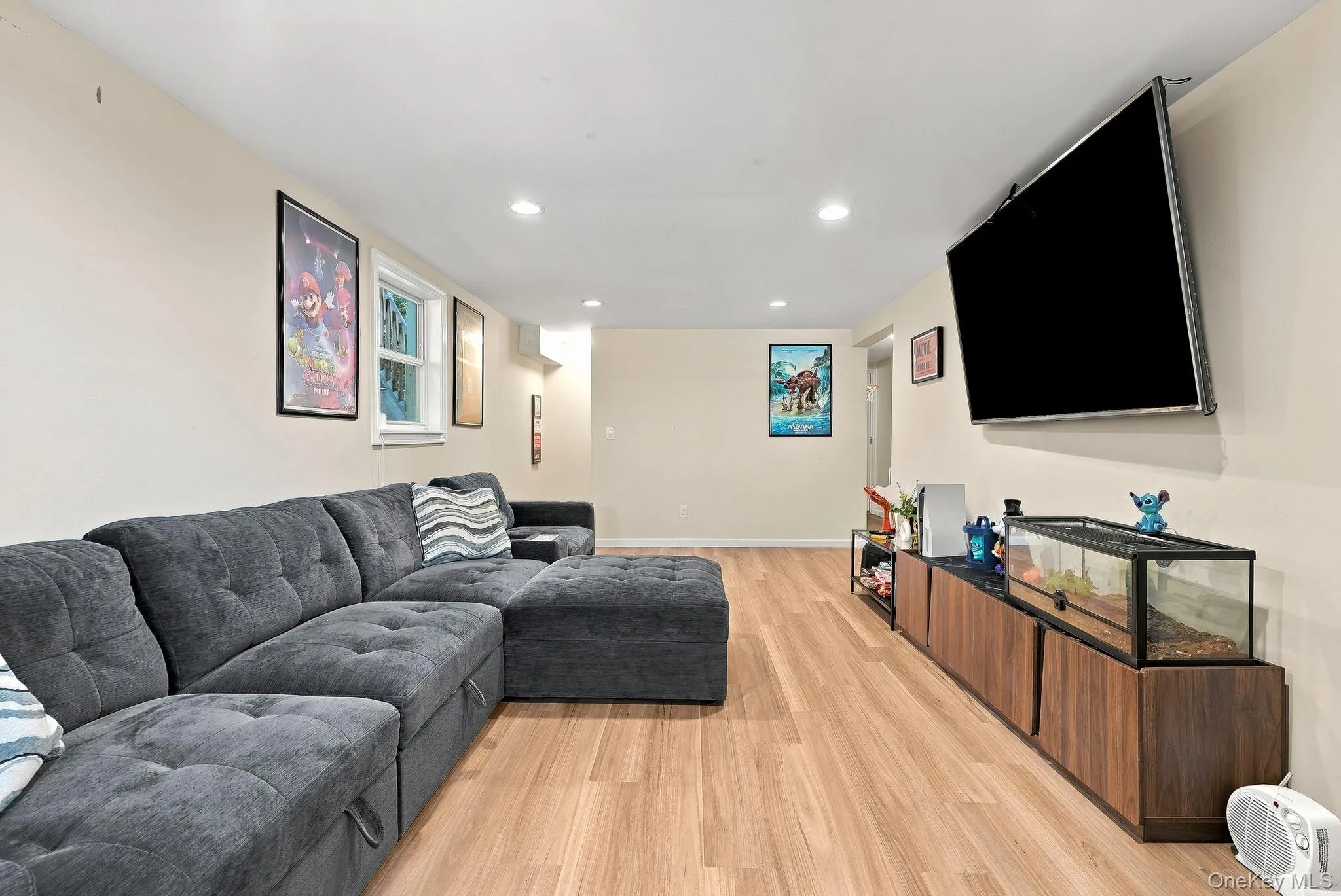 Neutral-toned room featuring wood-finish flooring, recessed lighting, and a window Neutral-toned room featuring wood-finish flooring, recessed lighting, and a window