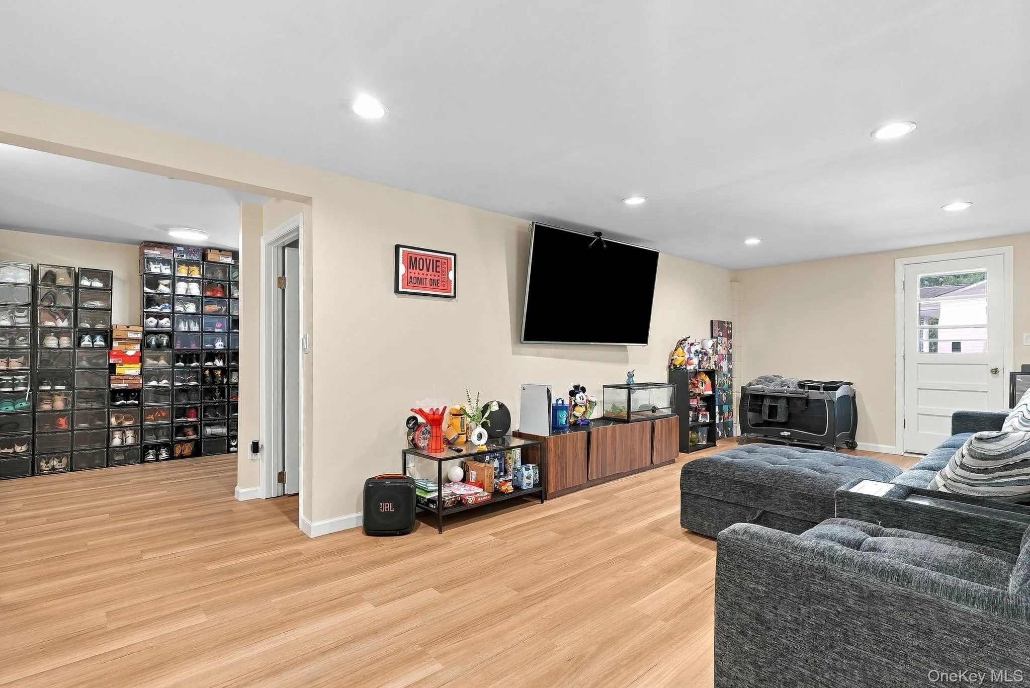 Open-concept room featuring wood-finish flooring, recessed lighting, and a glass-panel exterior door Open-concept room featuring wood-finish flooring, recessed lighting, and a glass-panel exterior door